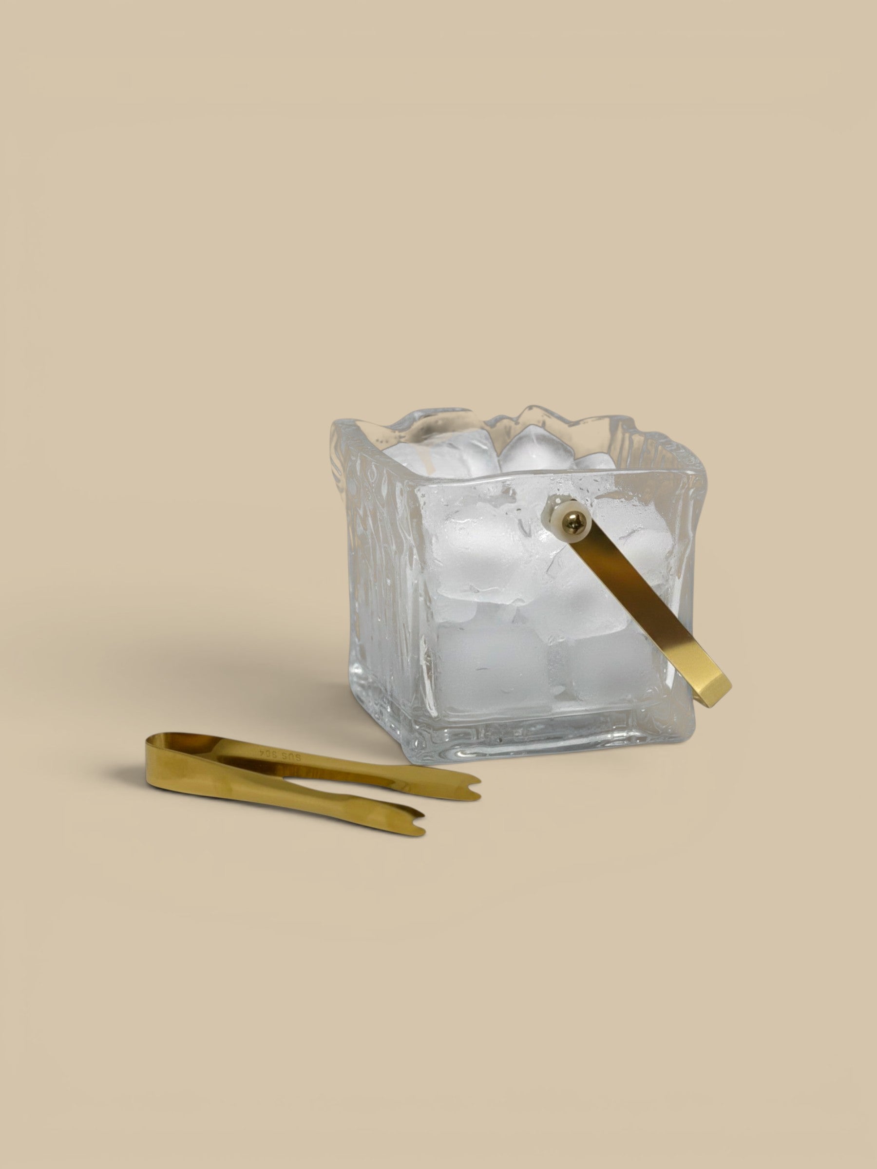 Homestyle Collective clear textured glass ice bucket with gold handle and tongs. Perfect for bar carts.