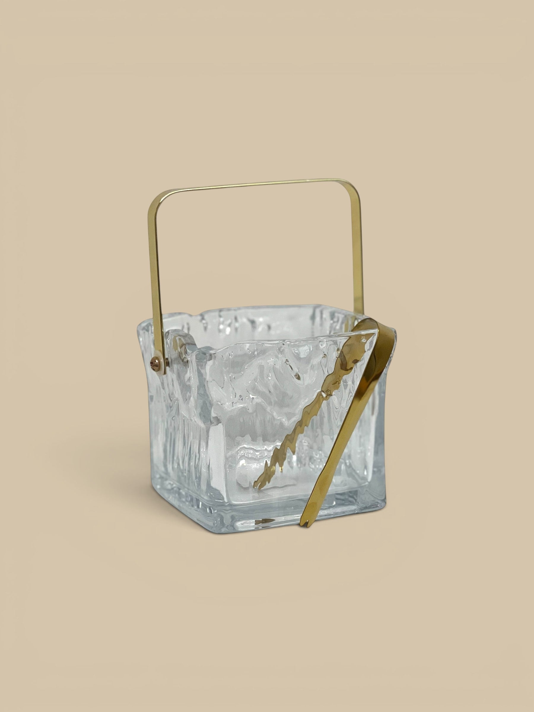 Homestyle Collective clear textured glass ice bucket with gold handle and tongs