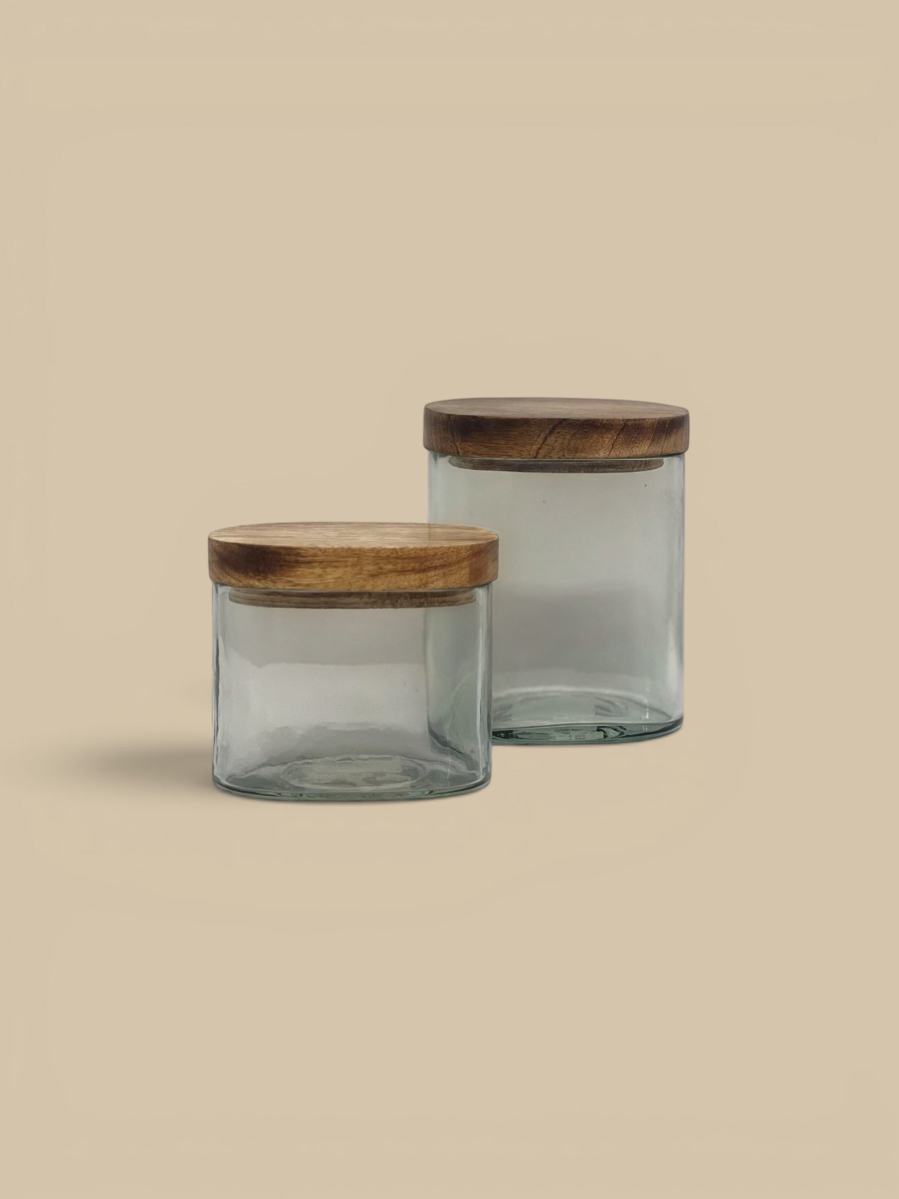 Homestyle Collective clear glass storage jars with natural wood lids, small and tall sizes for pantry or countertop.
