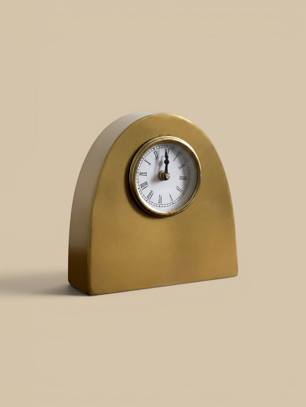 Homestyle Collective antique gold metal arch table clock with Roman numerals and white face.