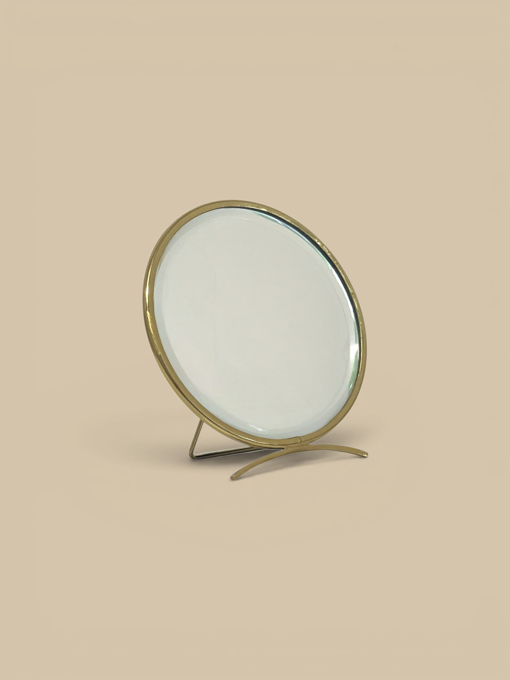 Homestyle Collective golden arc folding mirror with brass frame and adjustable metal base. Round vanity mirror.