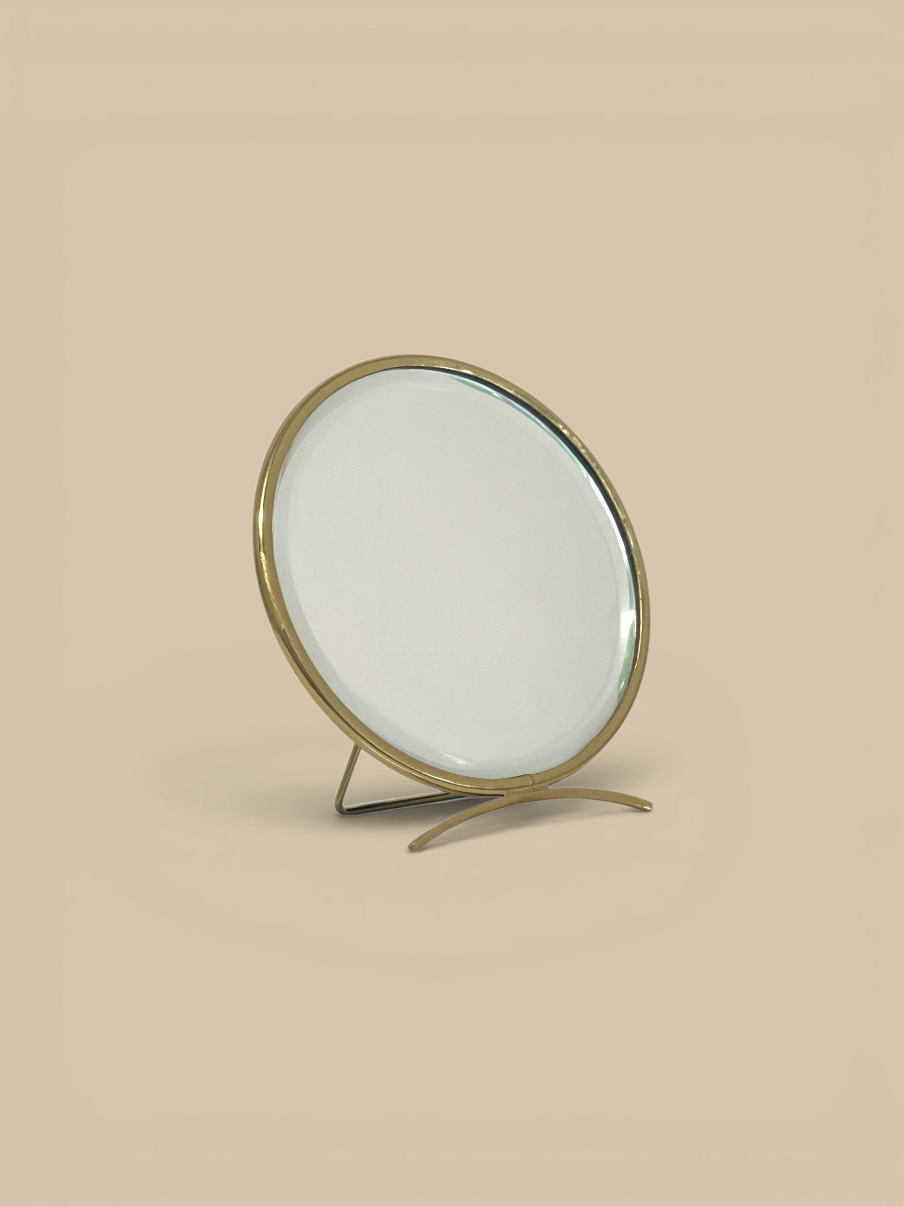 Homestyle Collective golden arc folding mirror with brass frame and adjustable metal base. Round vanity mirror.