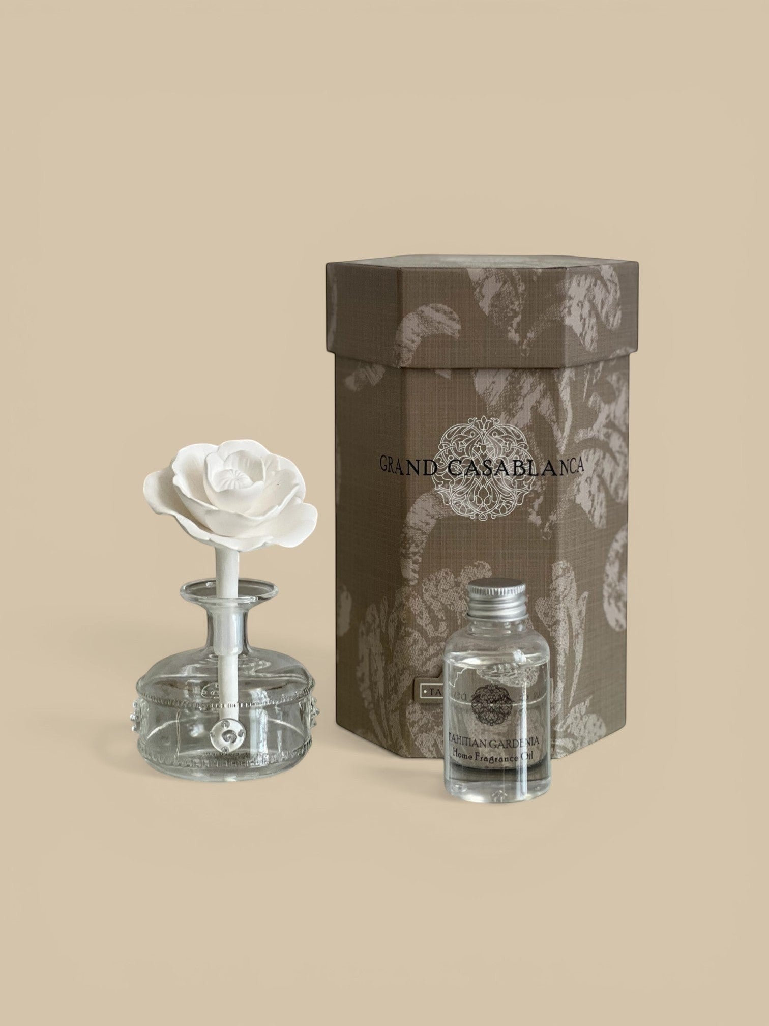 Homestyle Collective Grand Casablanca Tahitian Gardenia porcelain diffuser with a white rose bloom and fragrance oil bottle.