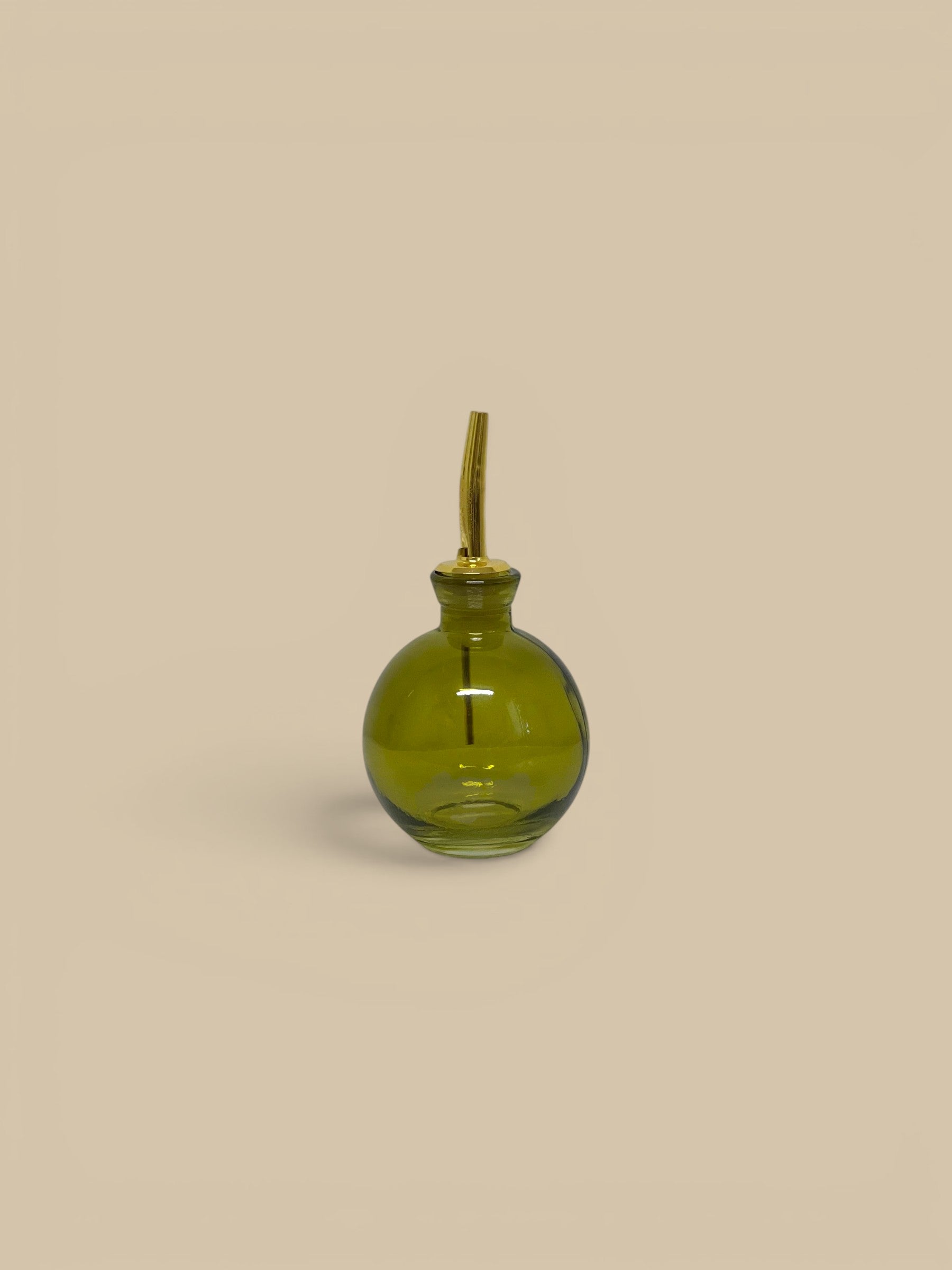 Homestyle Collective round green glass oil cruet with gold pour spout, 4 oz capacity.