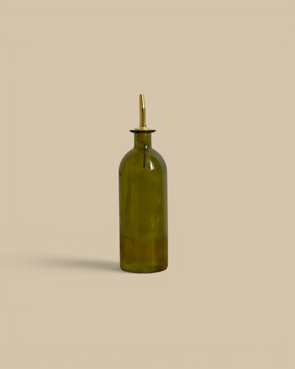 Homestyle Collective green glass oil cruets with metal pour spouts in tall and round shapes on a neutral background.