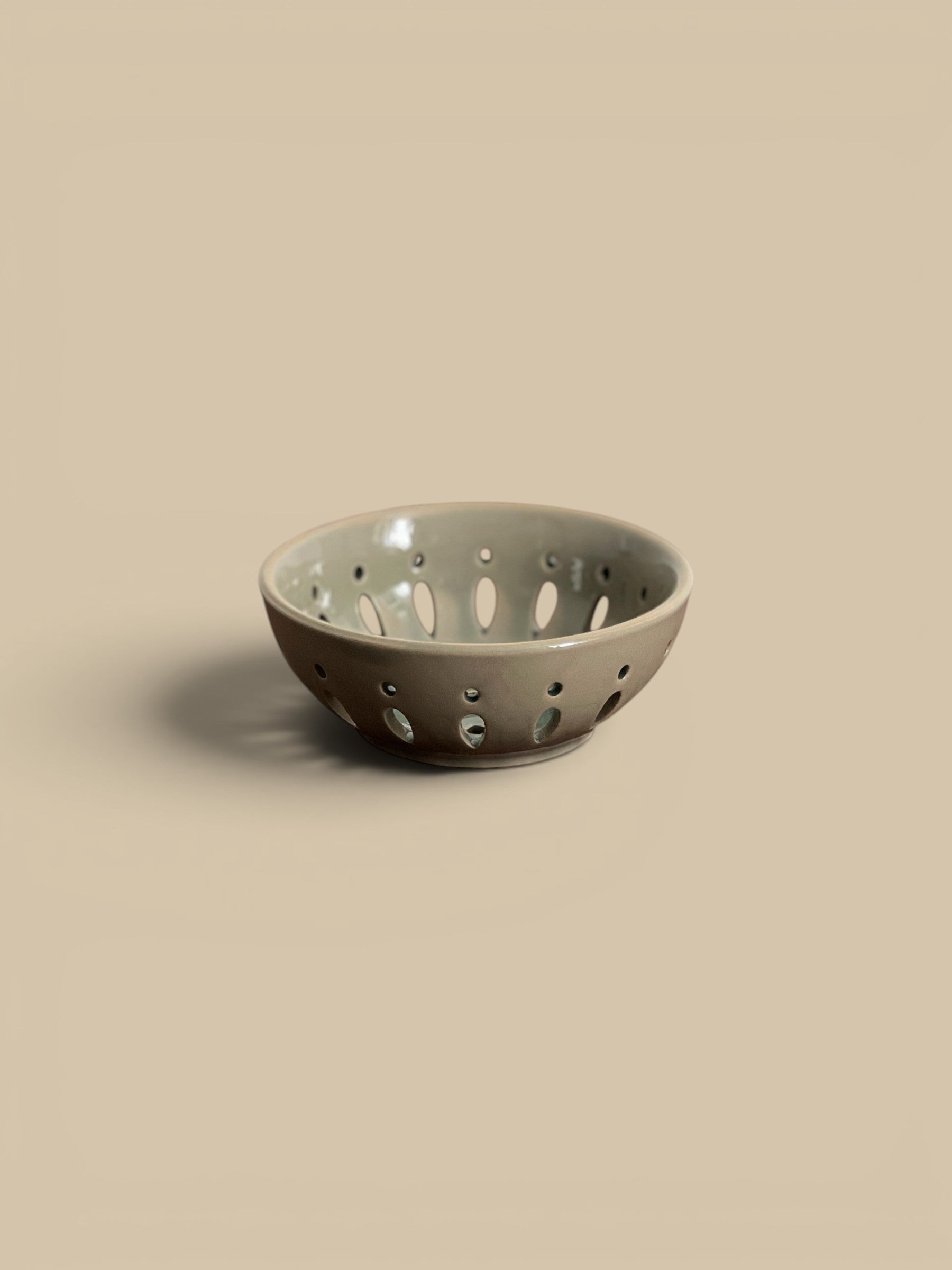 Homestyle Collective green/grey ceramic bowl with drainage holes, 5" round, ideal for serving fruit.