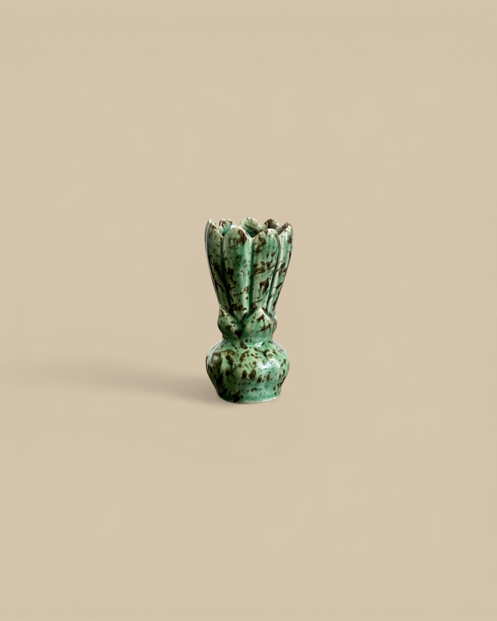 Homestyle Collective green stoneware vase shaped like a flower with sculpted petal ridges and scalloped opening.