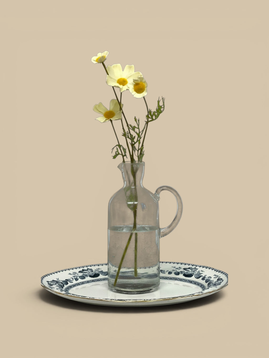 Homestyle Collective Santiago recycled glass carafe in grey with a handle, holding white flowers on a decorative tray.