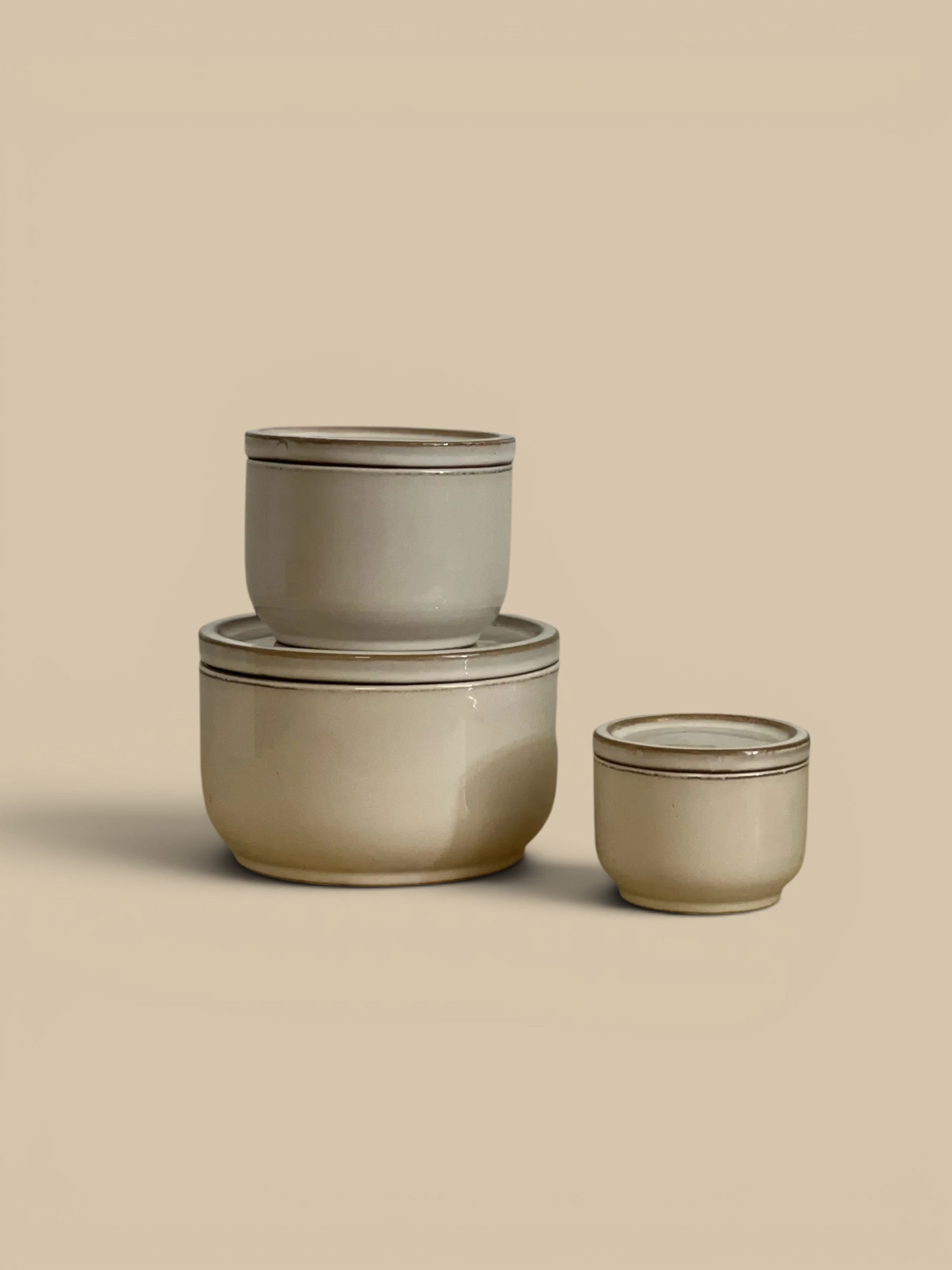 Homestyle Collective set of 3 ivory ceramic lidded jars with subtle gold trim. Classic design for decor.