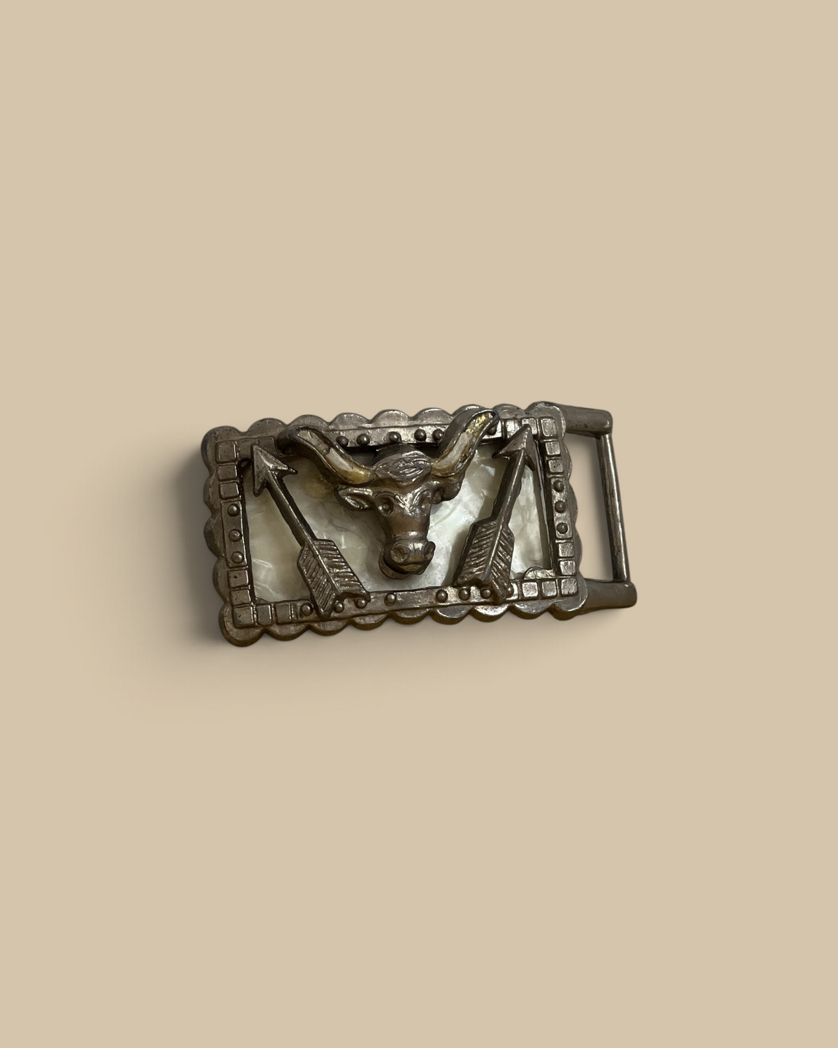 Homestyle Collective cast iron longhorn belt buckle with resin inlay and arrow detailing on a rustic surface.