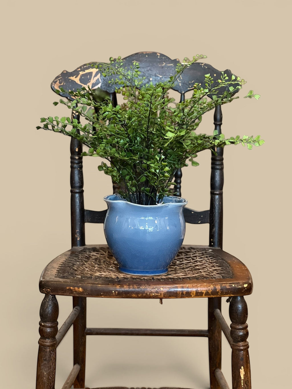 Homestyle Collective lifelike maidenhair fern in a blue ceramic pot on a vintage wooden chair.