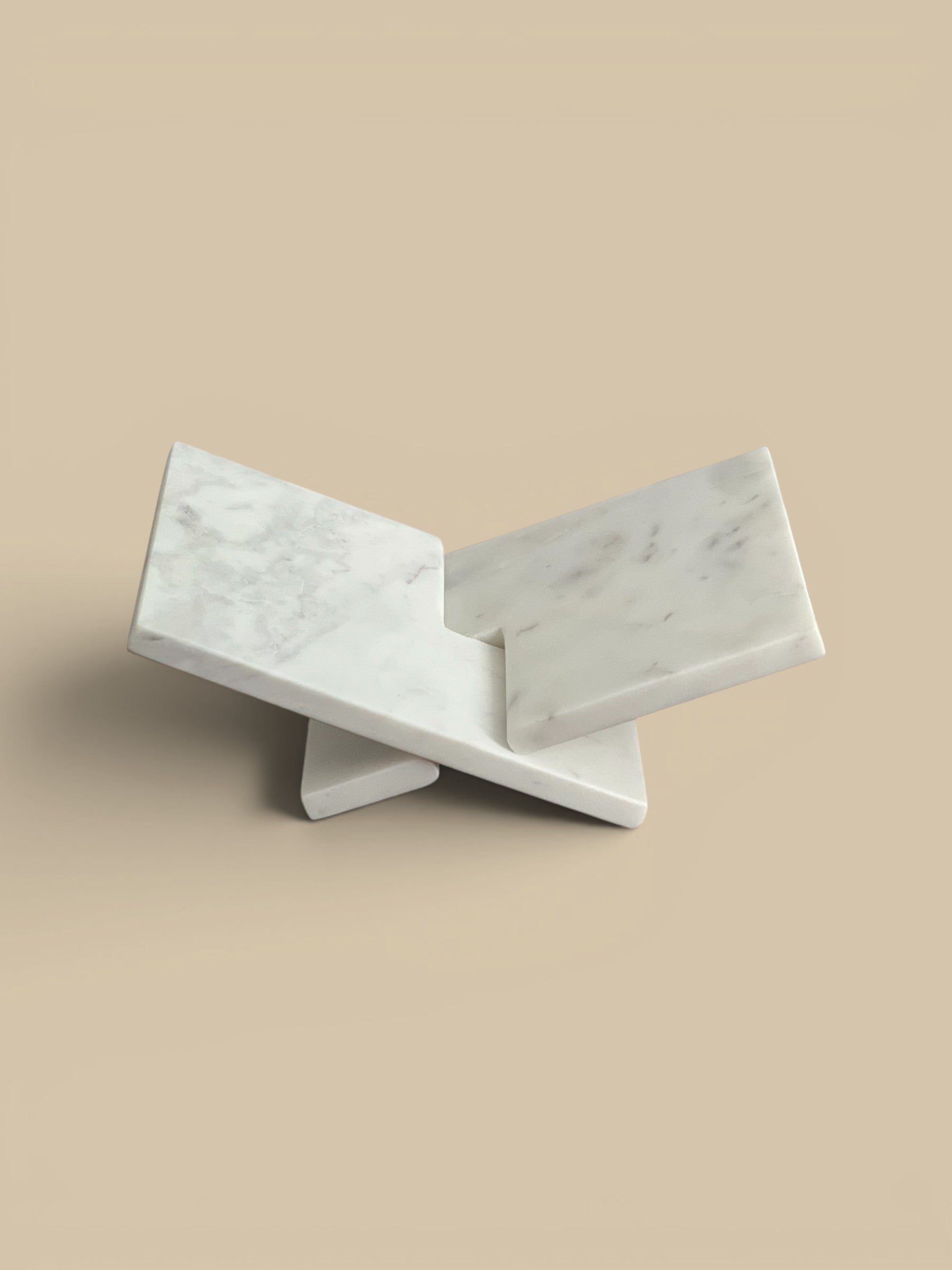 Homestyle Collective interlocking white marble book display stand with grey veining.