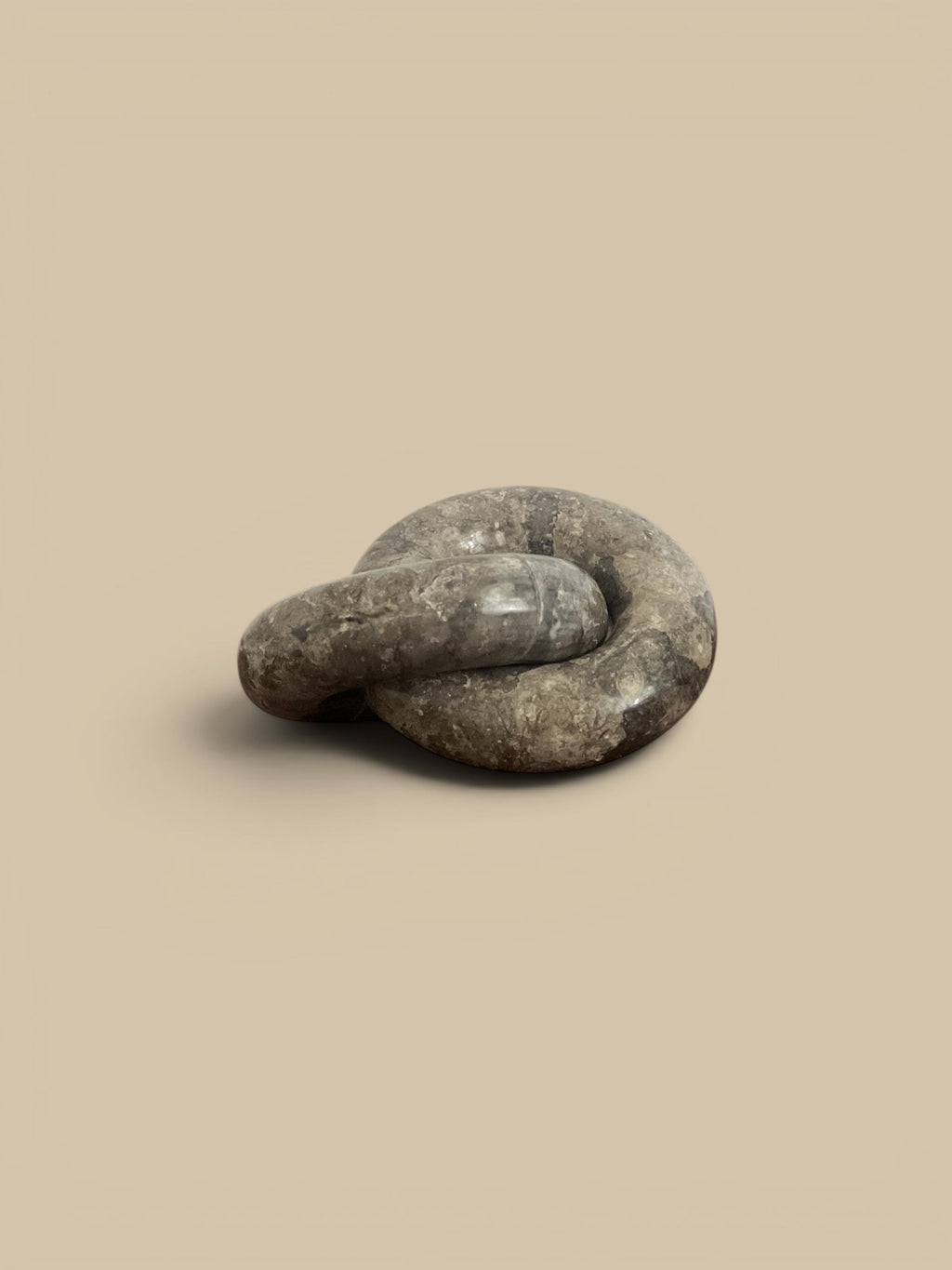 Homestyle Collective linked ring sculpture in brown veined marble, with a semi-matte sheen.