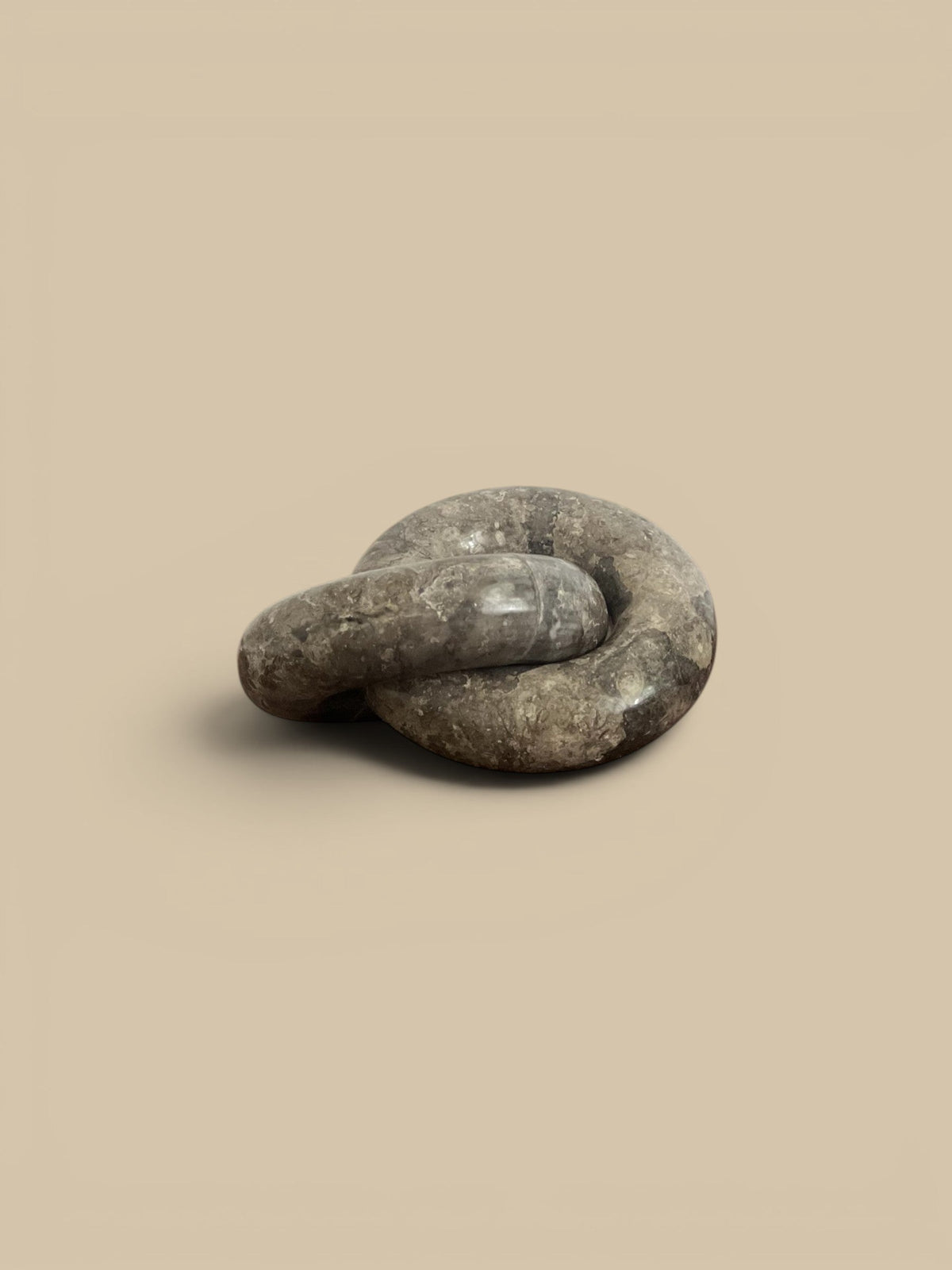 Homestyle Collective linked ring sculpture in brown veined marble, with a semi-matte sheen.