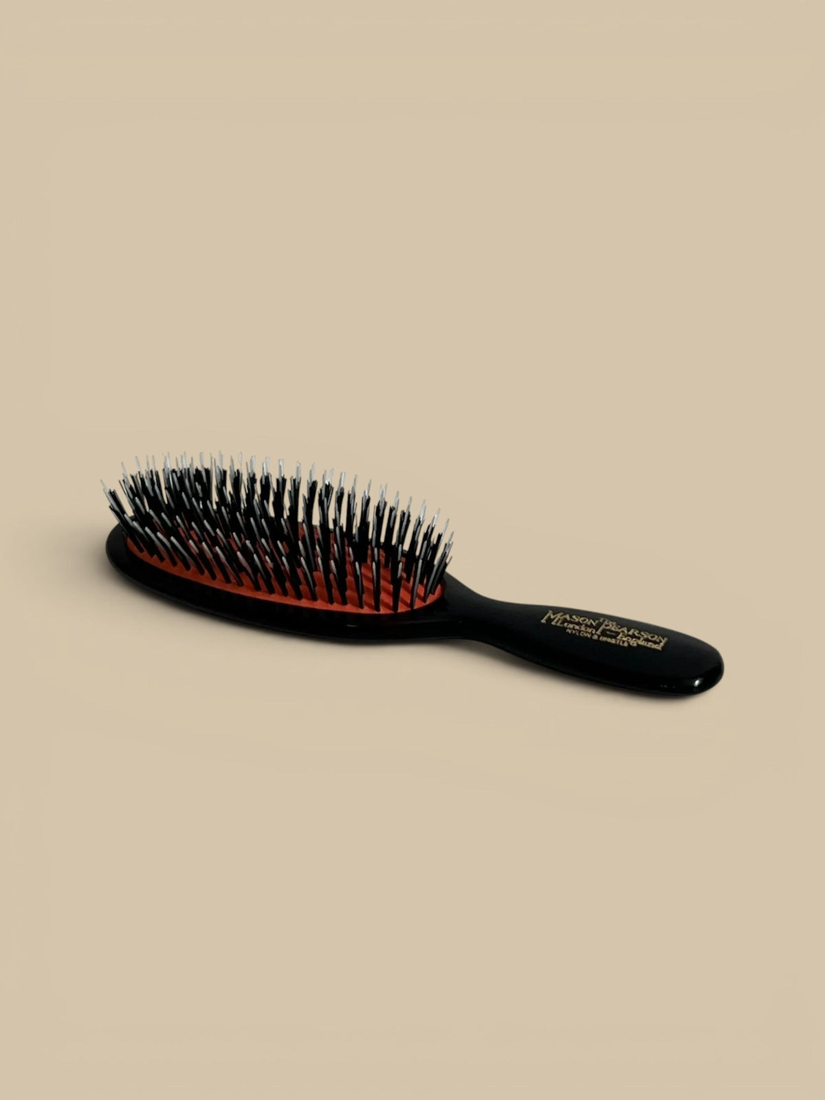 Homestyle Collective Mason Pearson Dark Ruby Pocket Brush with black handle and orange cushion
