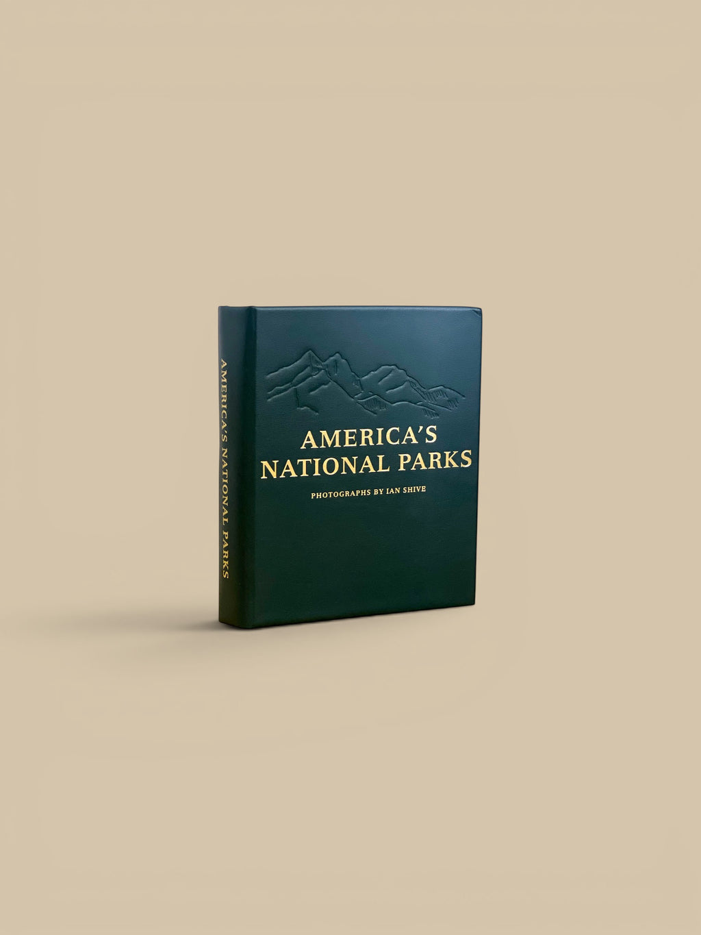 Homestyle Collective America's National Parks leather-bound edition book with embossed mountain range and gold lettering.