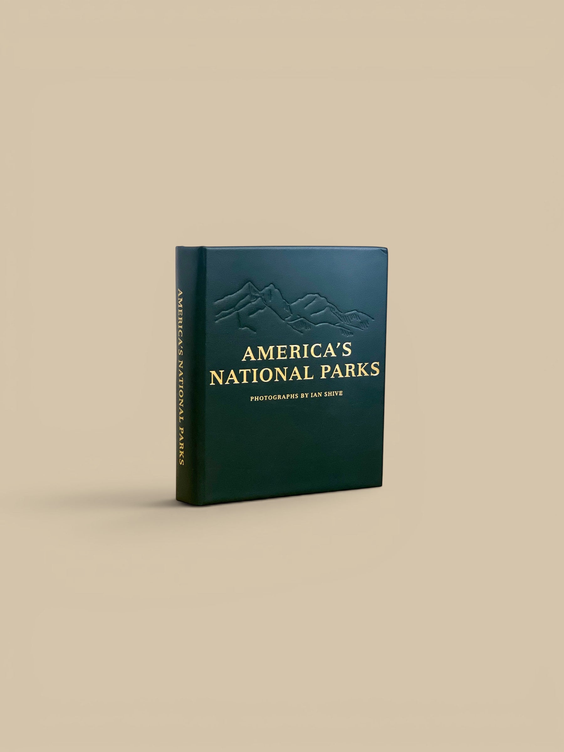 Homestyle Collective America's National Parks leather-bound edition book with embossed mountain range and gold lettering.