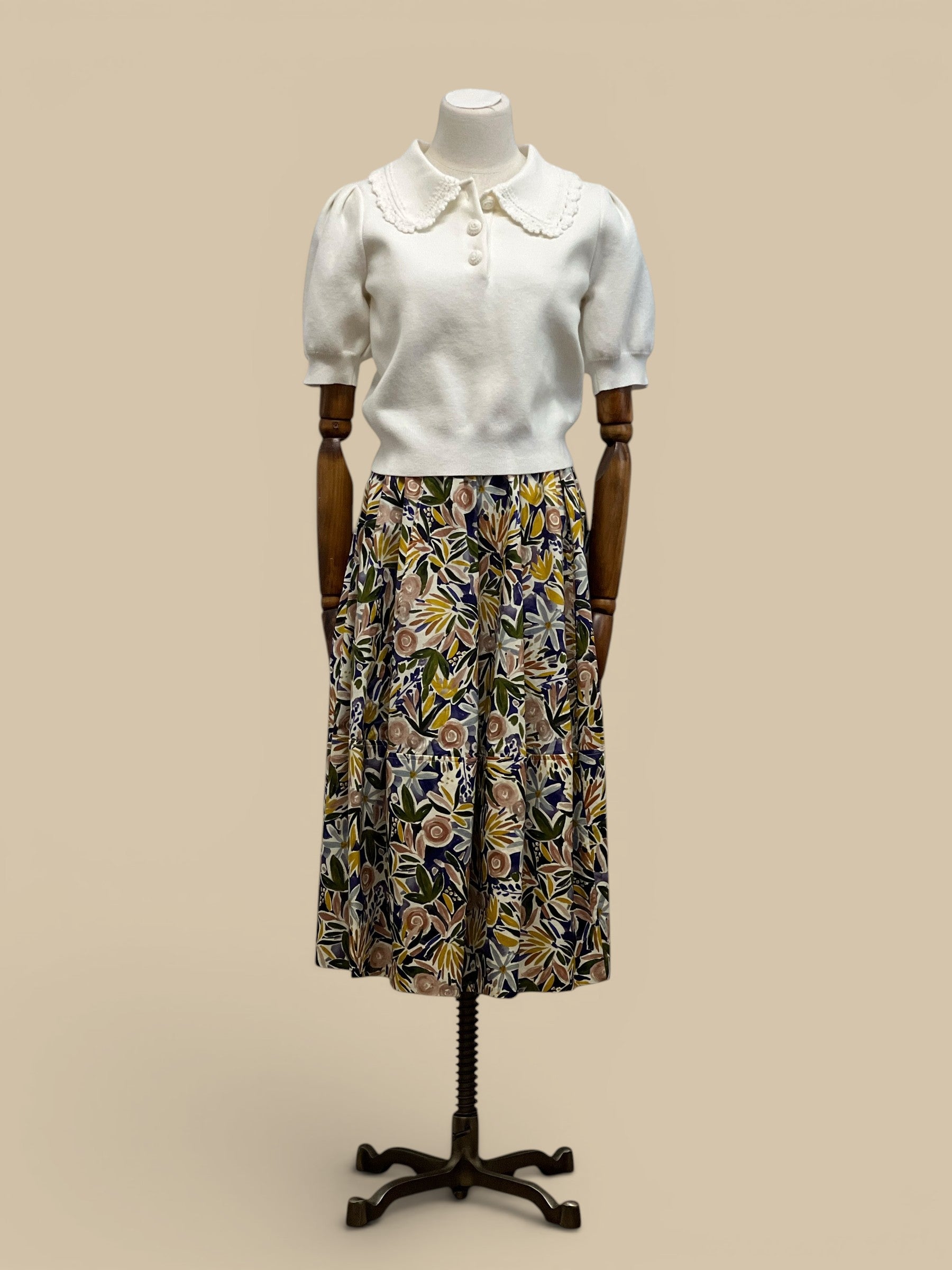 Homestyle Collective off-white knit top with puff sleeves and a scalloped collar, paired with a floral print midi skirt.