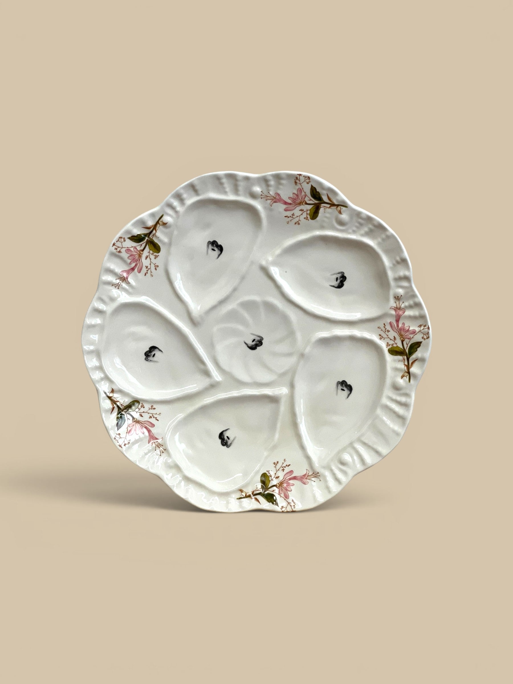 Homestyle Collective white stoneware oyster plate with six wells and delicate pink floral accents, 8" round.