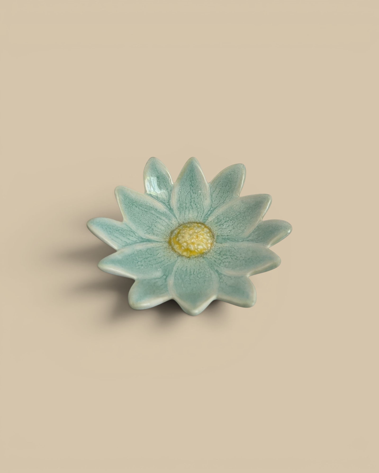 Homestyle Collective light blue stoneware flower dish with yellow center, 4.5" round.