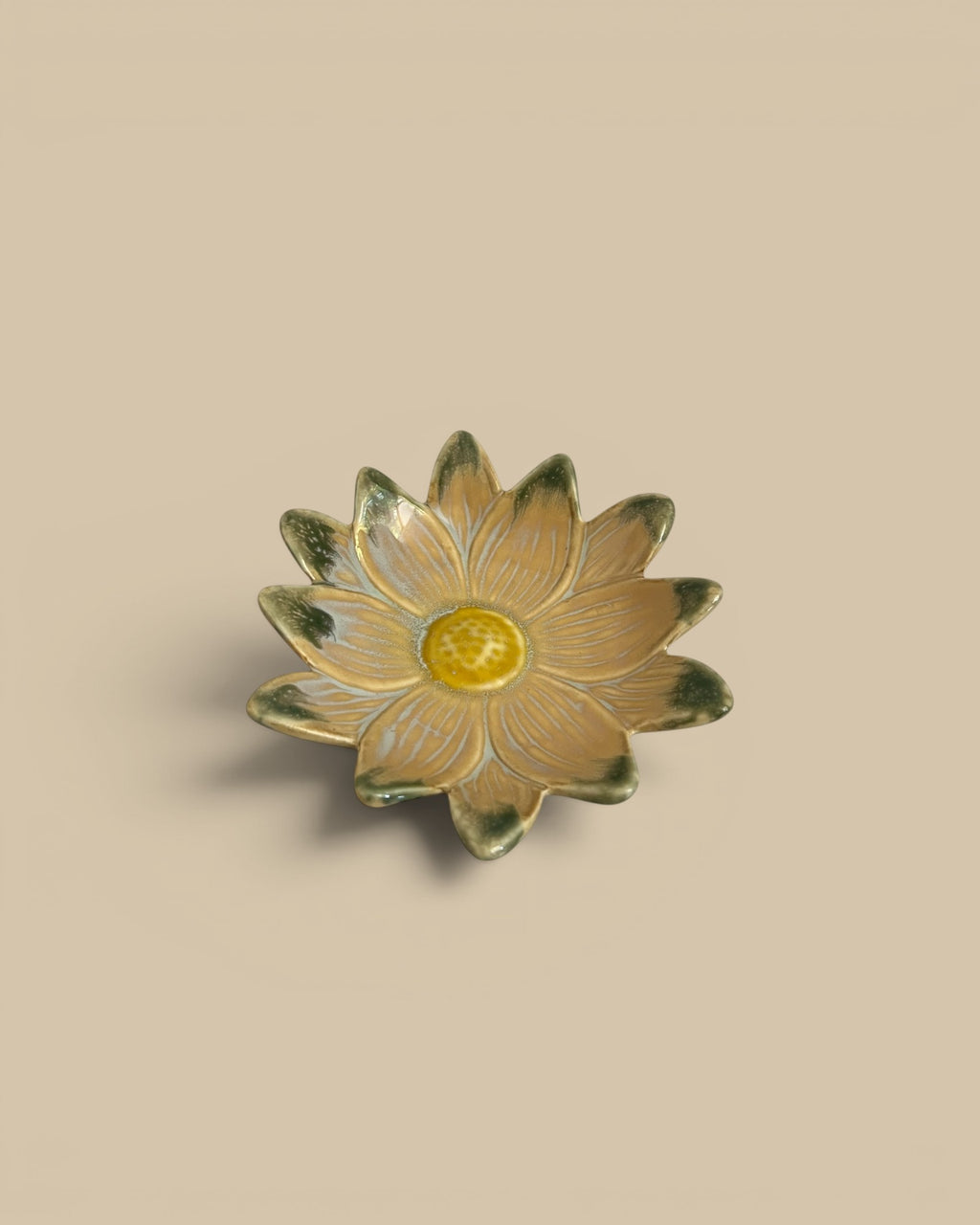Homestyle Collective Petal Pop stoneware dish in a flower shape with a yellow center and tan petals with green accents.