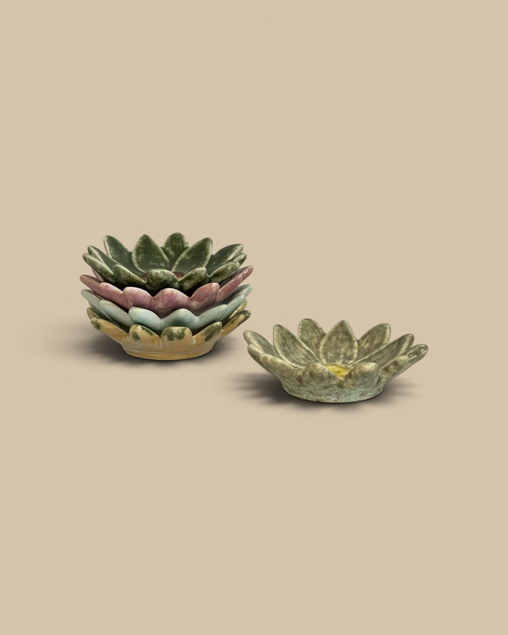 Homestyle Collective stoneware flower-shaped dishes in pastel green, pink, blue, and yellow hues. Stacked and single dish shown.