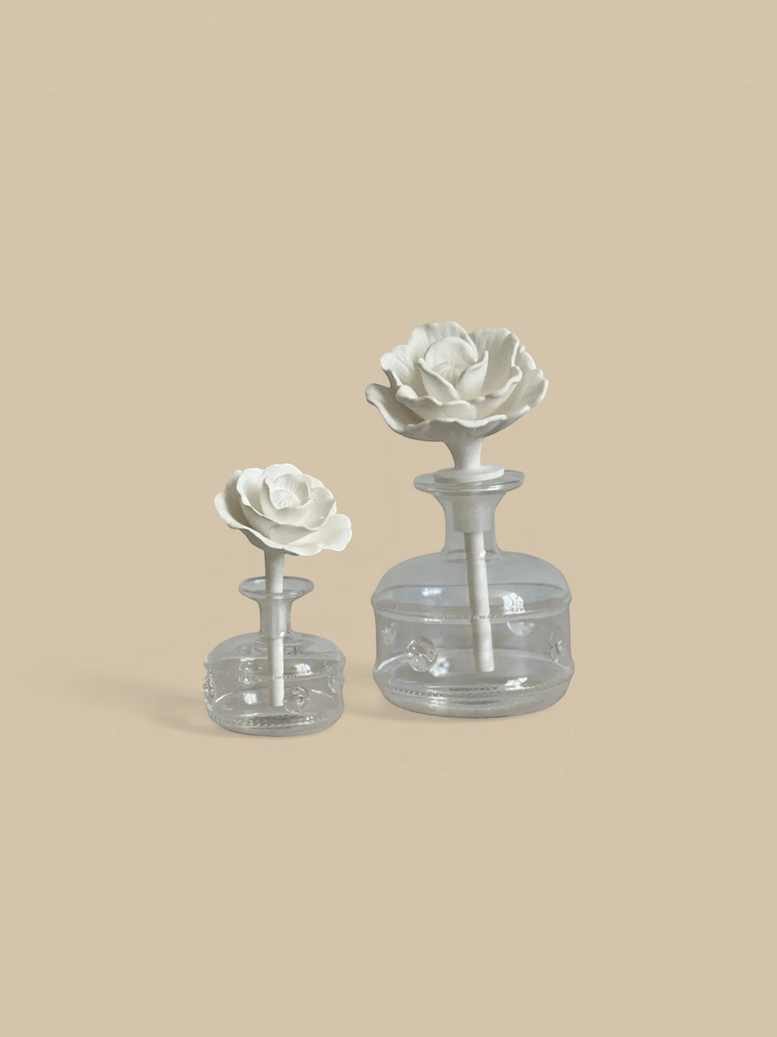Homestyle Collective Grand Casablanca Porcelain Diffuser in Tahitian Gardenia scent, featuring a white porcelain rose bloom and clear glass bottle with decorative accents.