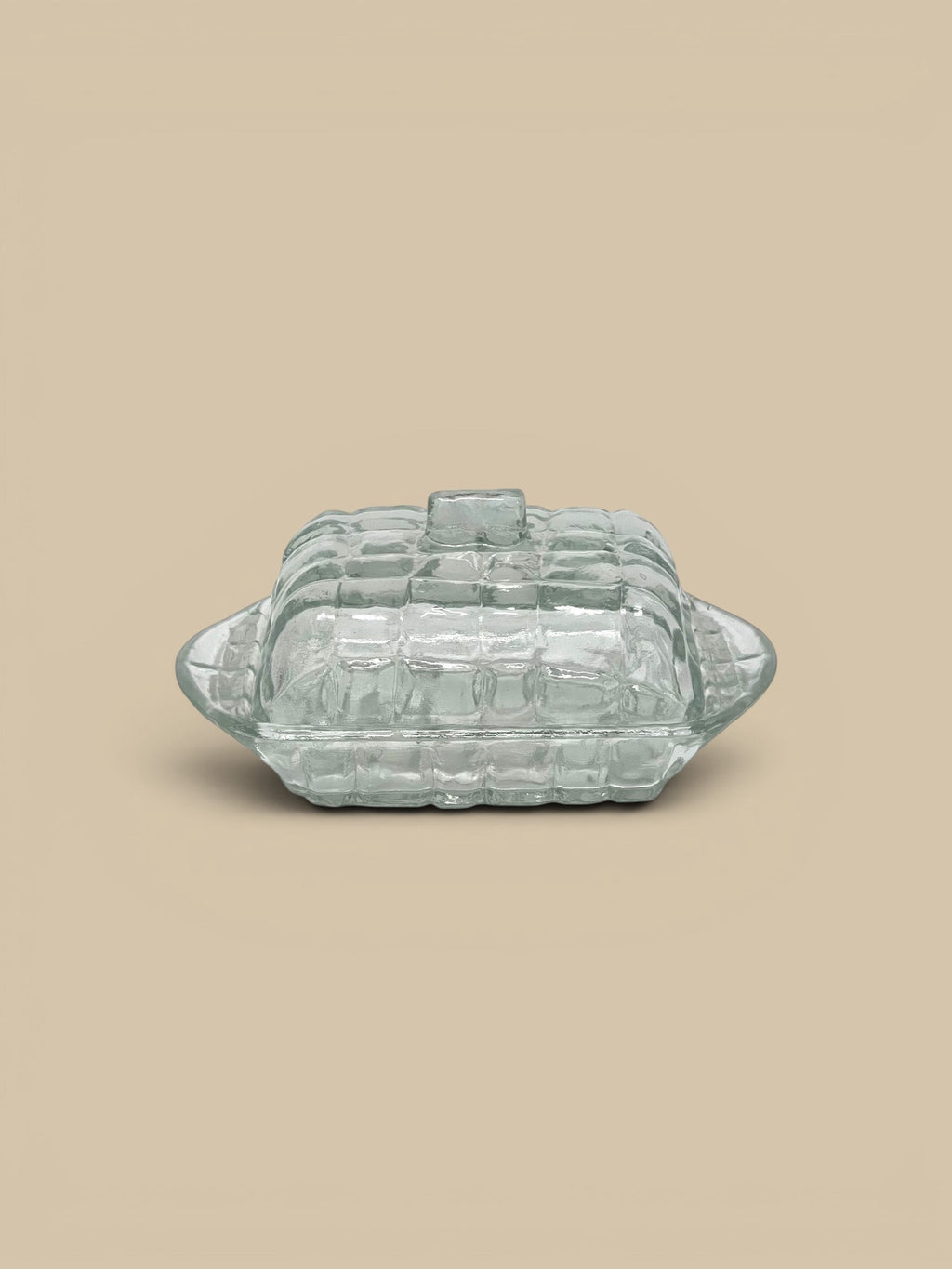 Homestyle Collective clear pressed glass butter dish with textured grid pattern and easy-grip handle.