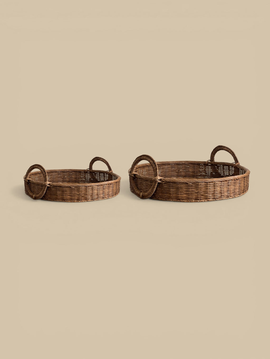 Homestyle Collective natural woven rattan oval tray with loop handles, set of 2. Warm organic finish.