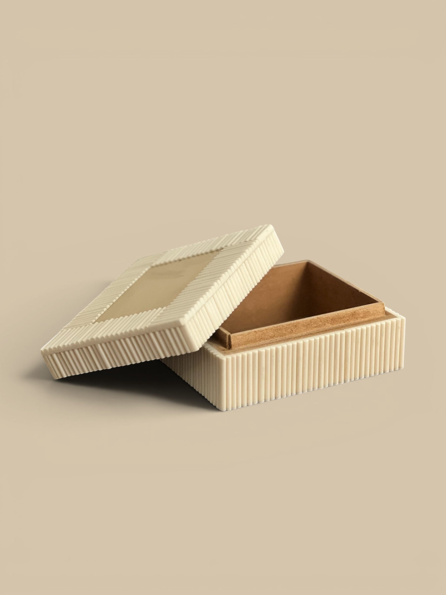 Homestyle Collective ivory bone accent box with ribbed exterior and smooth lid, open to show interior.