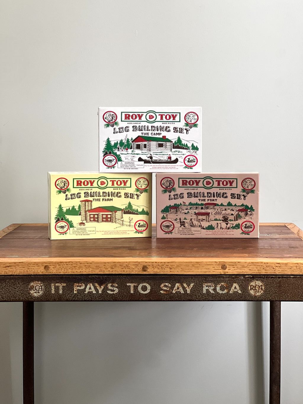 Homestyle Collective Roy Toy 1930s Log Building Set boxes: The Camp, The Farm, and The Fort. Wooden toy construction sets.