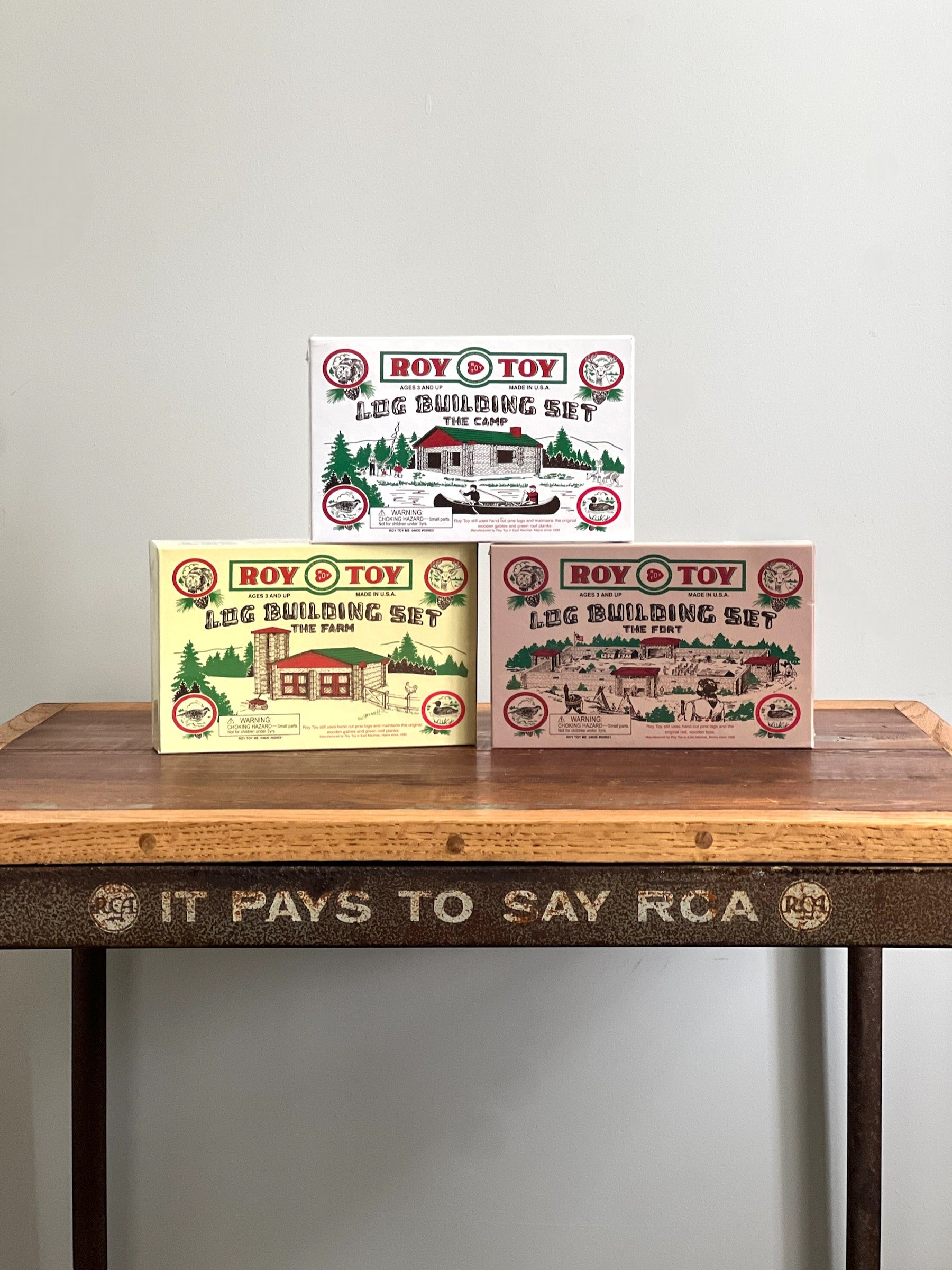 Homestyle Collective Roy Toy 1930s Log Building Set boxes: The Camp, The Farm, and The Fort. Wooden toy construction sets.