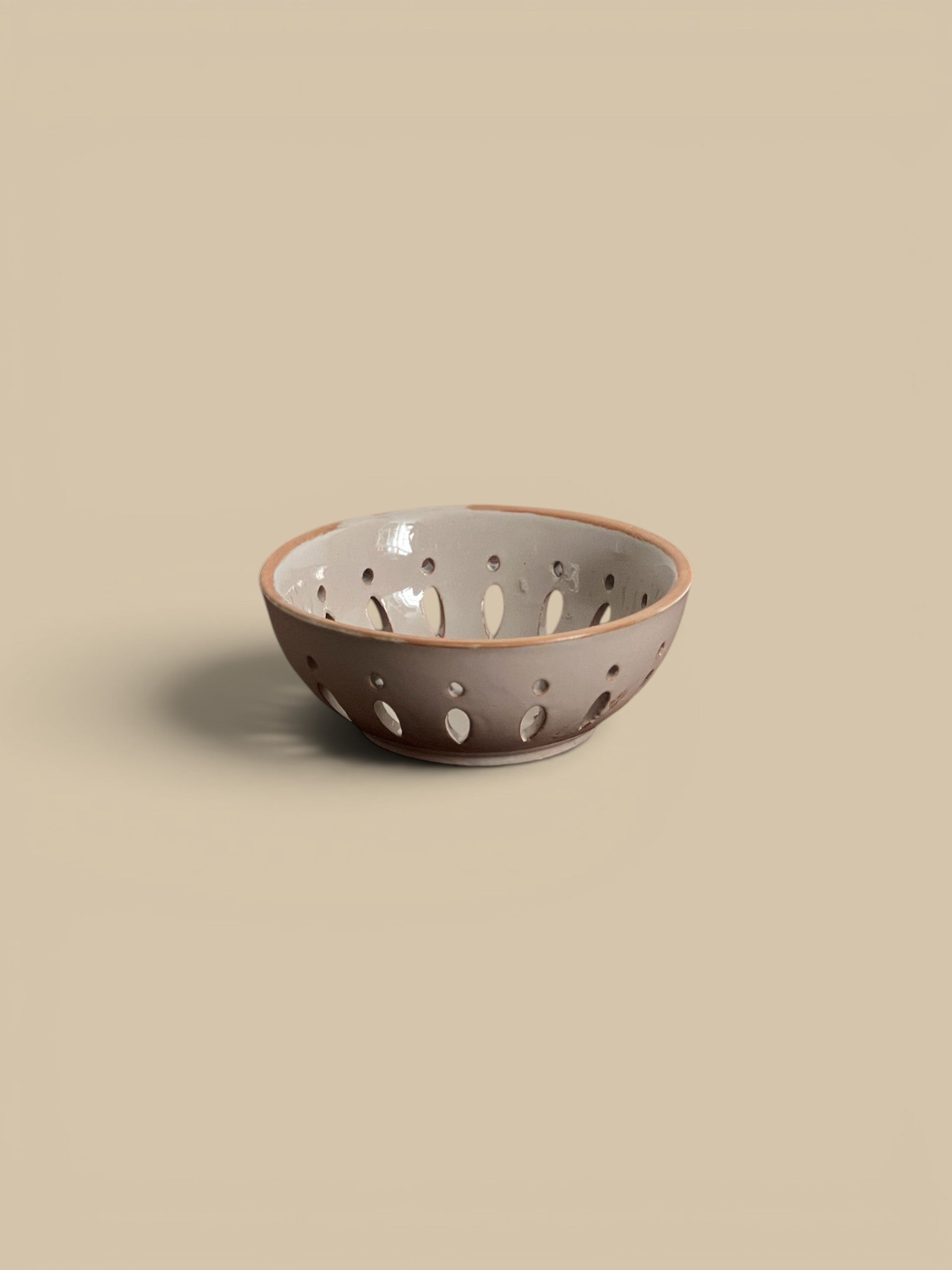 Homestyle Collective sand ceramic bowl with cut-out details, perfect for serving fruit.