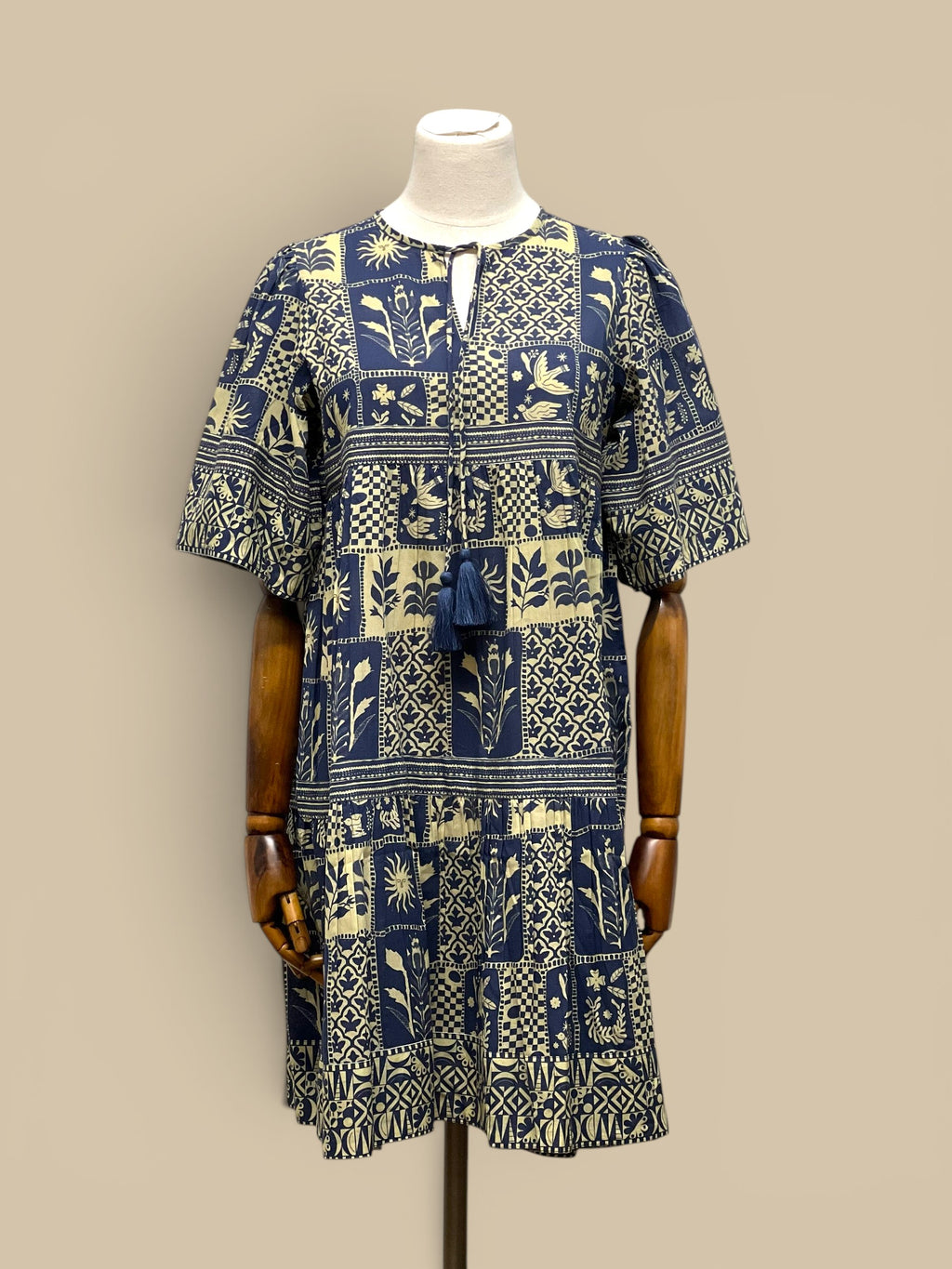 Homestyle Collective Sohana Patches Dress, a 100% cotton, handmade midi dress with a blue and cream block print pattern, tassel detail, and tiered skirt.