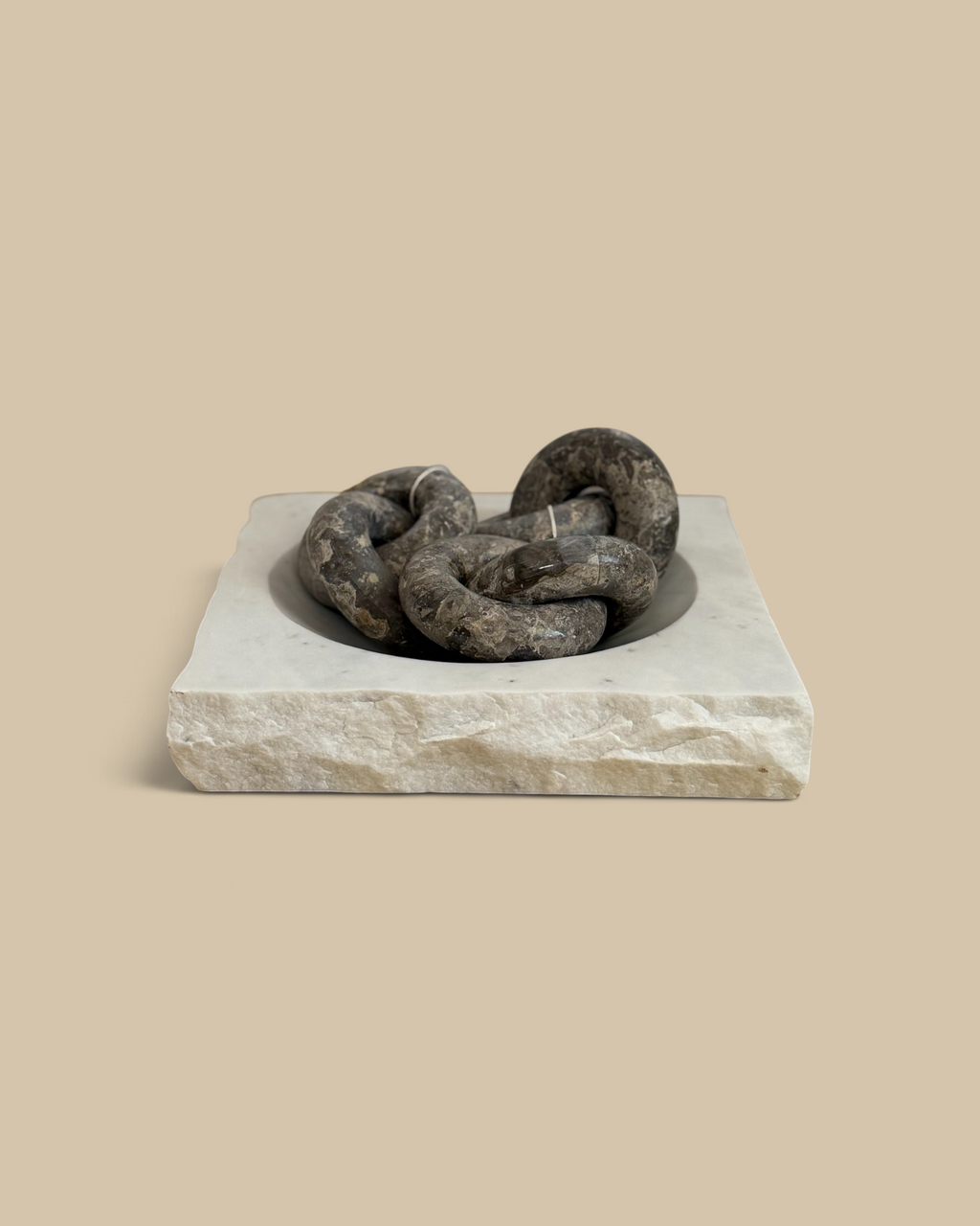 Homestyle Collective square marble bowl with a textured rock-finish edge holding decorative grey stone chain links.