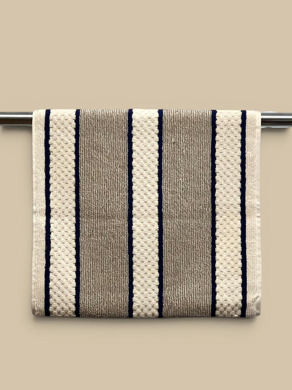 Homestyle Collective cream, taupe, and navy striped cotton hand towel with popper fastening for hanging.