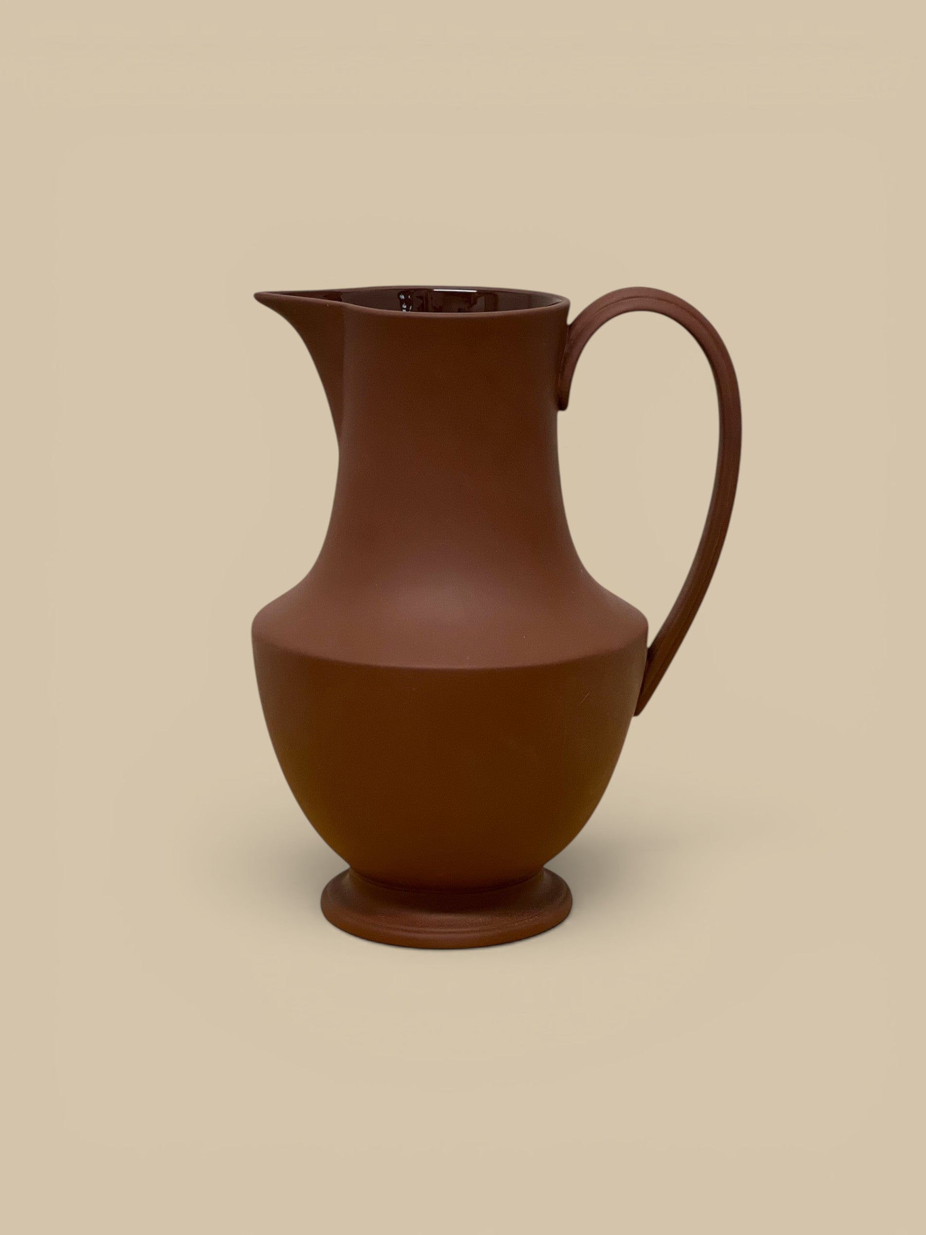 Homestyle Collective terra cotta stoneware pitcher with a matte finish, elegant curves, and a wide base. Handmade in Sri Lanka.