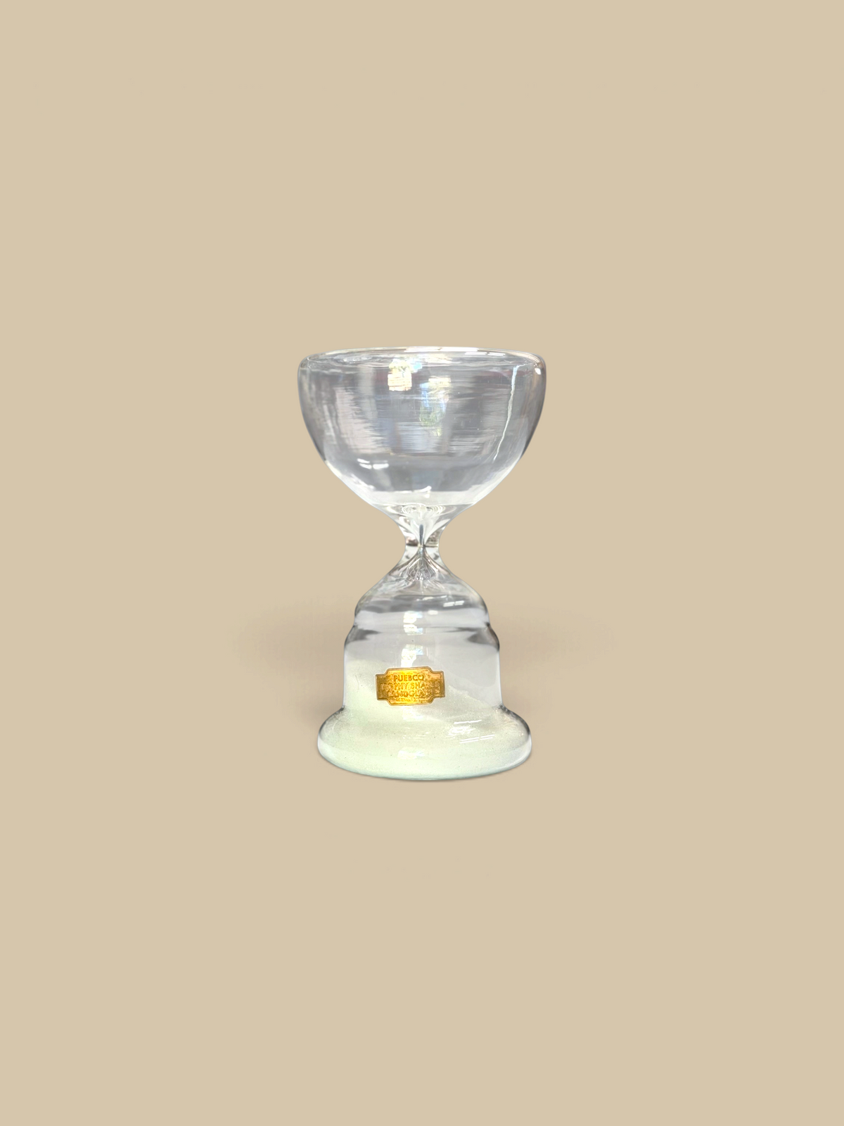 Homestyle Collective trophy-shaped glass hourglass with white sand, perfect for elegant desk or shelf decor.