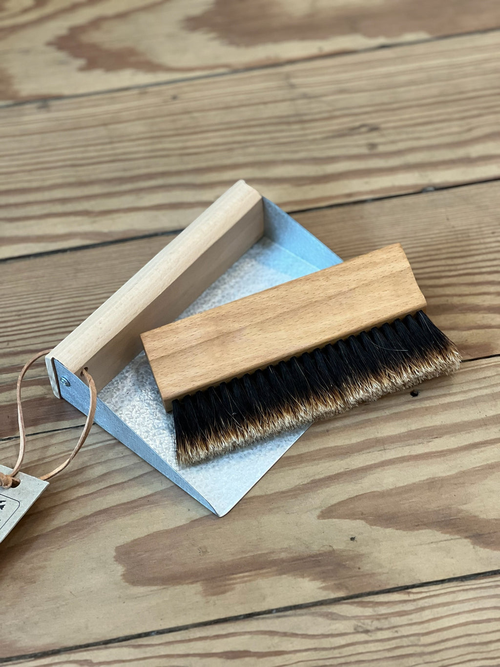 Homestyle Collective Urbana table brush set with natural fiber bristles and oiled beechwood handle nested in a galvanized metal pan.