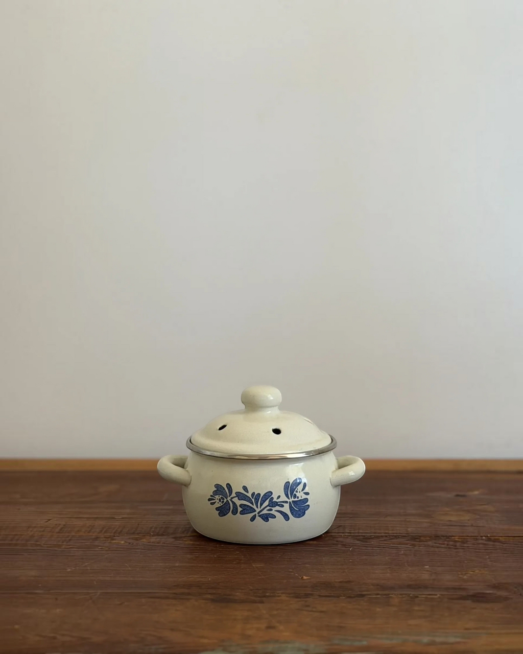 Homestyle Collective vintage enamel simmer pot in cream with blue floral pattern, vented lid, and side handles.