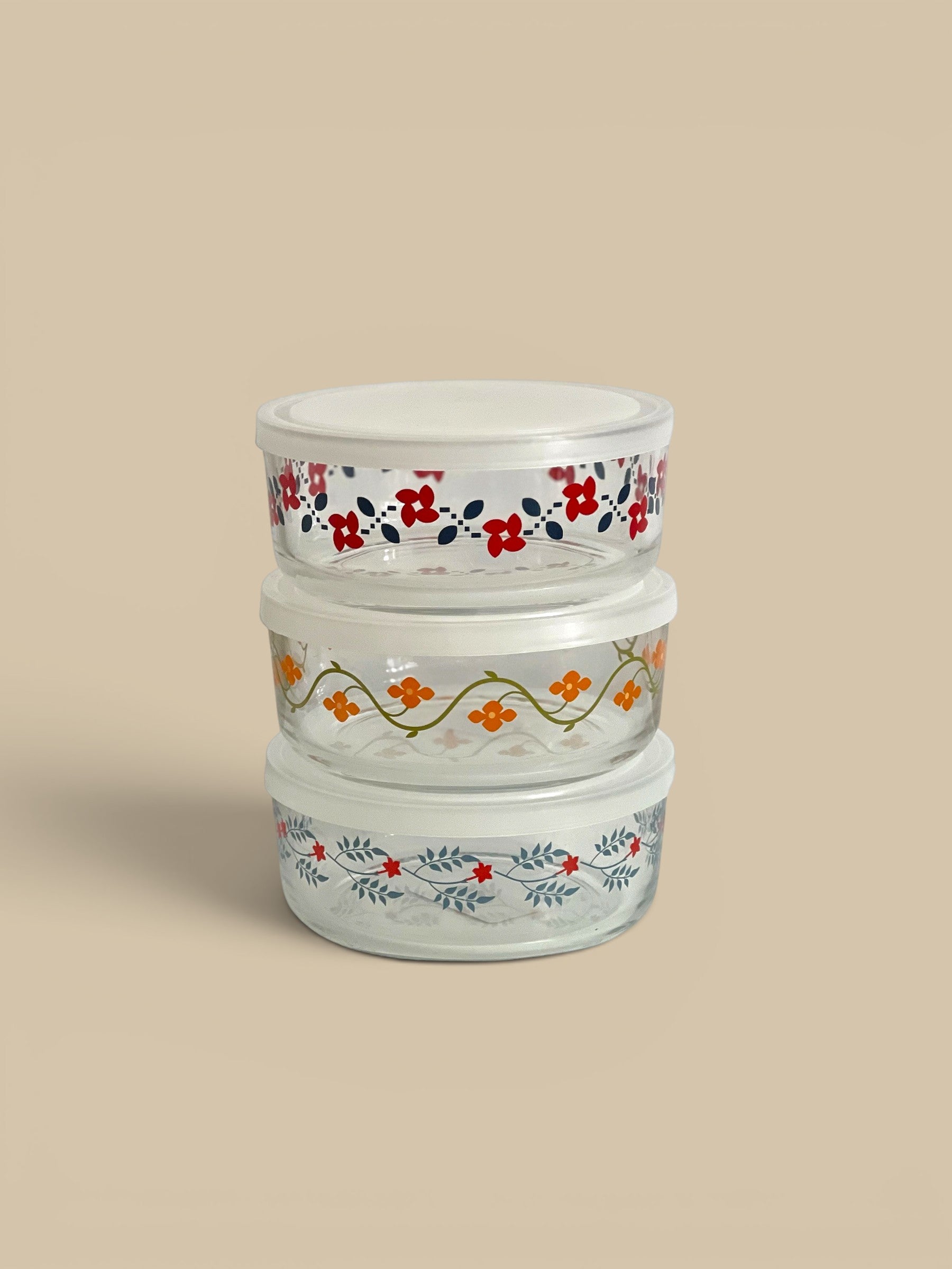 Homestyle Collective vintage glass storage bowls with lids, featuring floral patterns in red, orange, and blue. Set of 3.