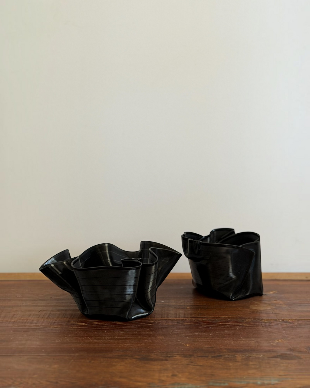 Homestyle Collective set of two black melted vintage vinyl record bowls on a rustic wooden surface.