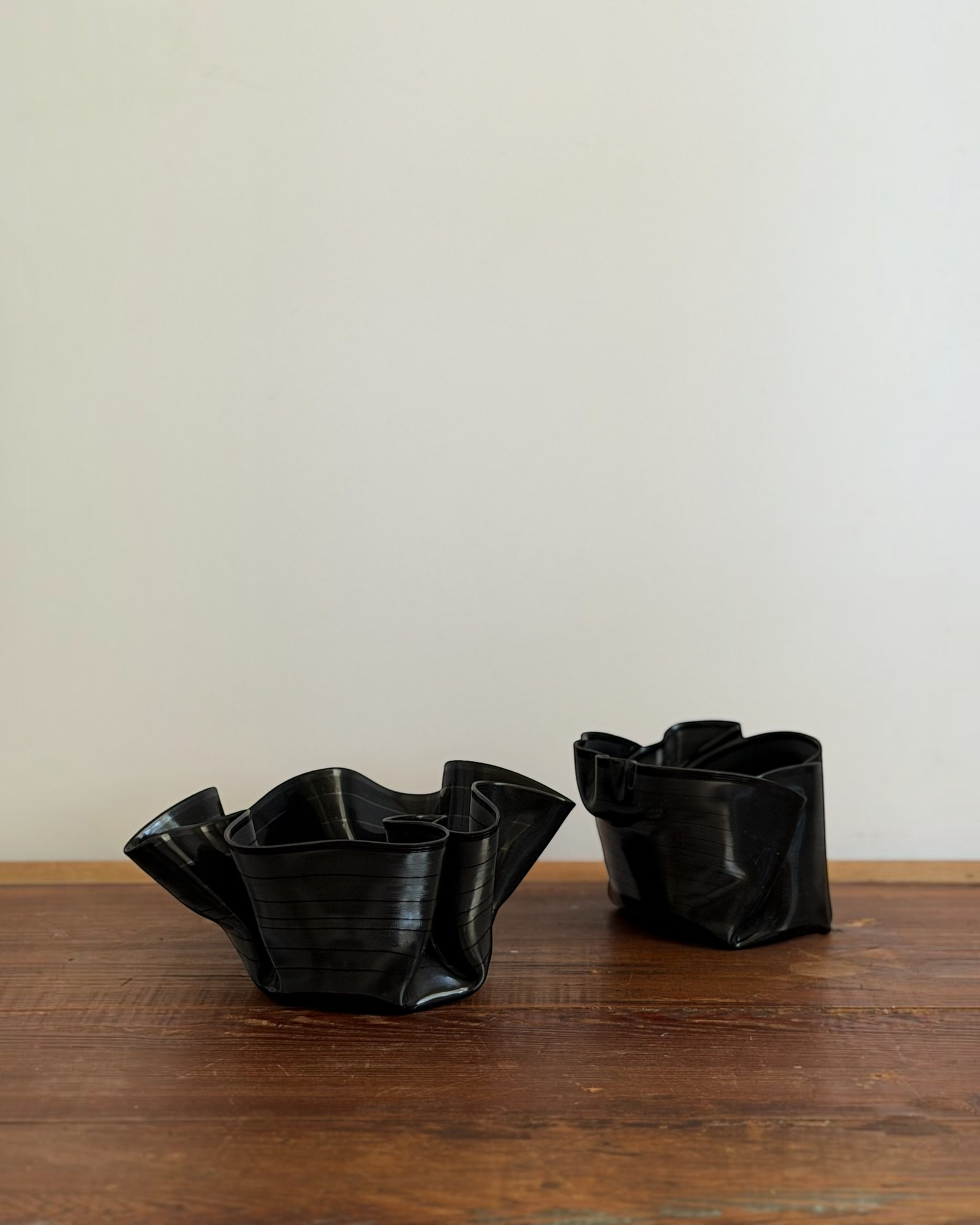 Homestyle Collective set of two black melted vintage vinyl record bowls on a rustic wooden surface.