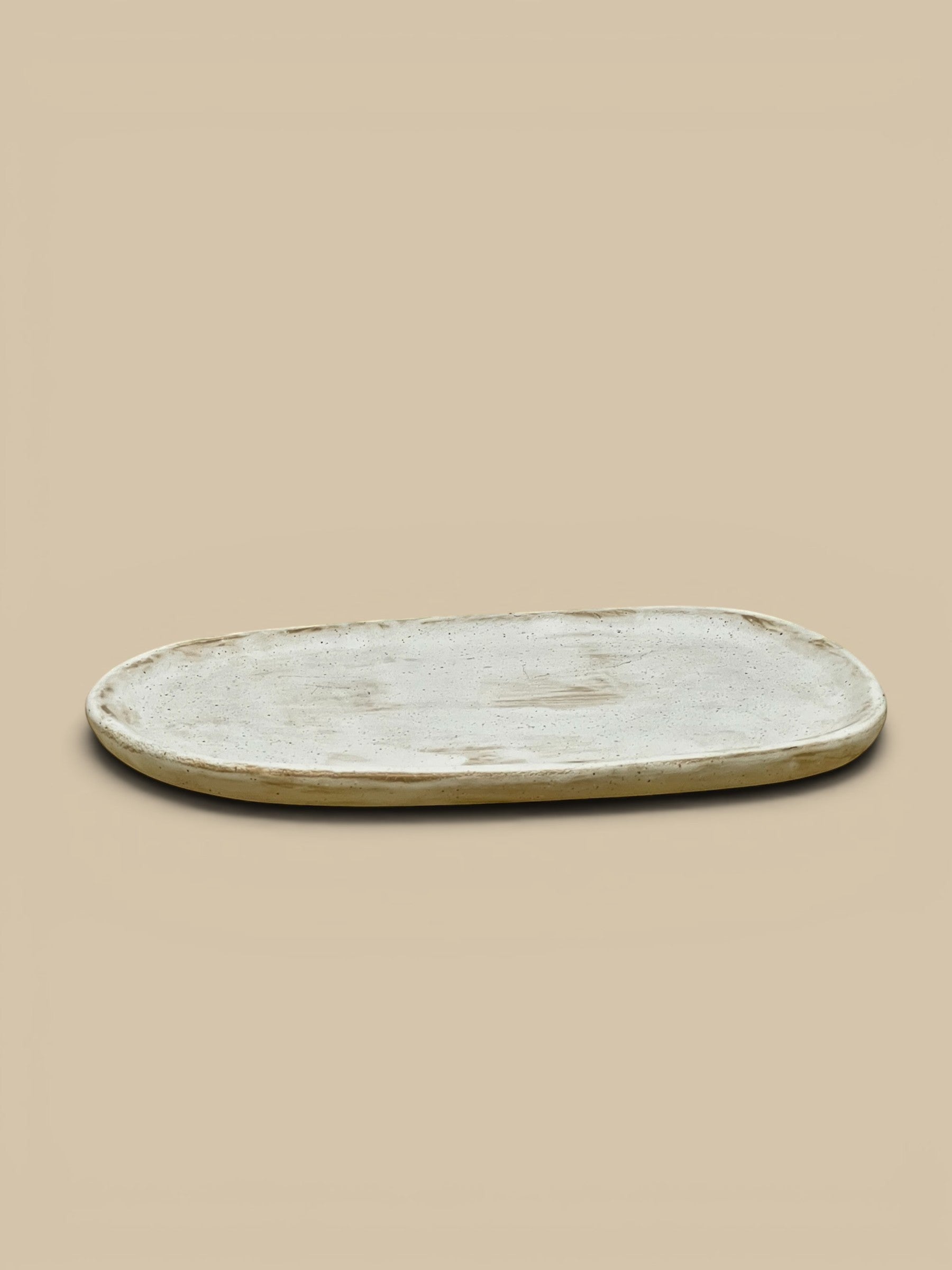 Homestyle Collective Wabi Oval Serving Plate in off-white ceramic with organic form, 10" L x 6.75" W.