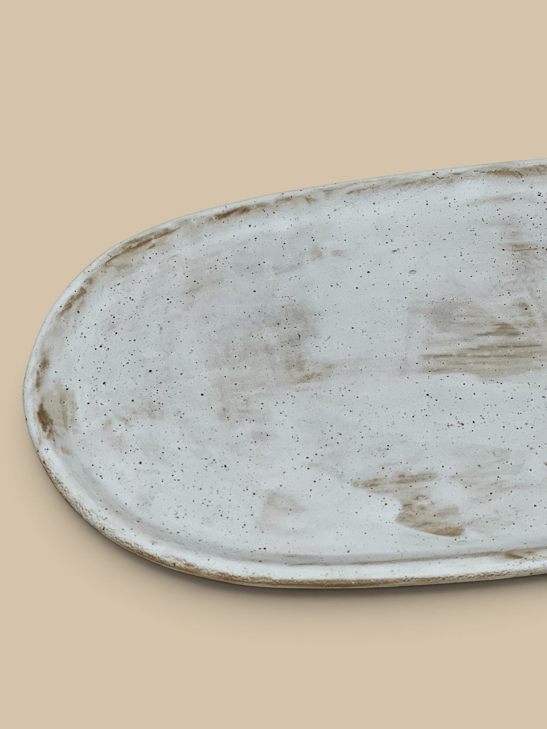 Homestyle Collective Wabi Oval Serving Plate in off-white ceramic with organic form and subtle brown speckles.