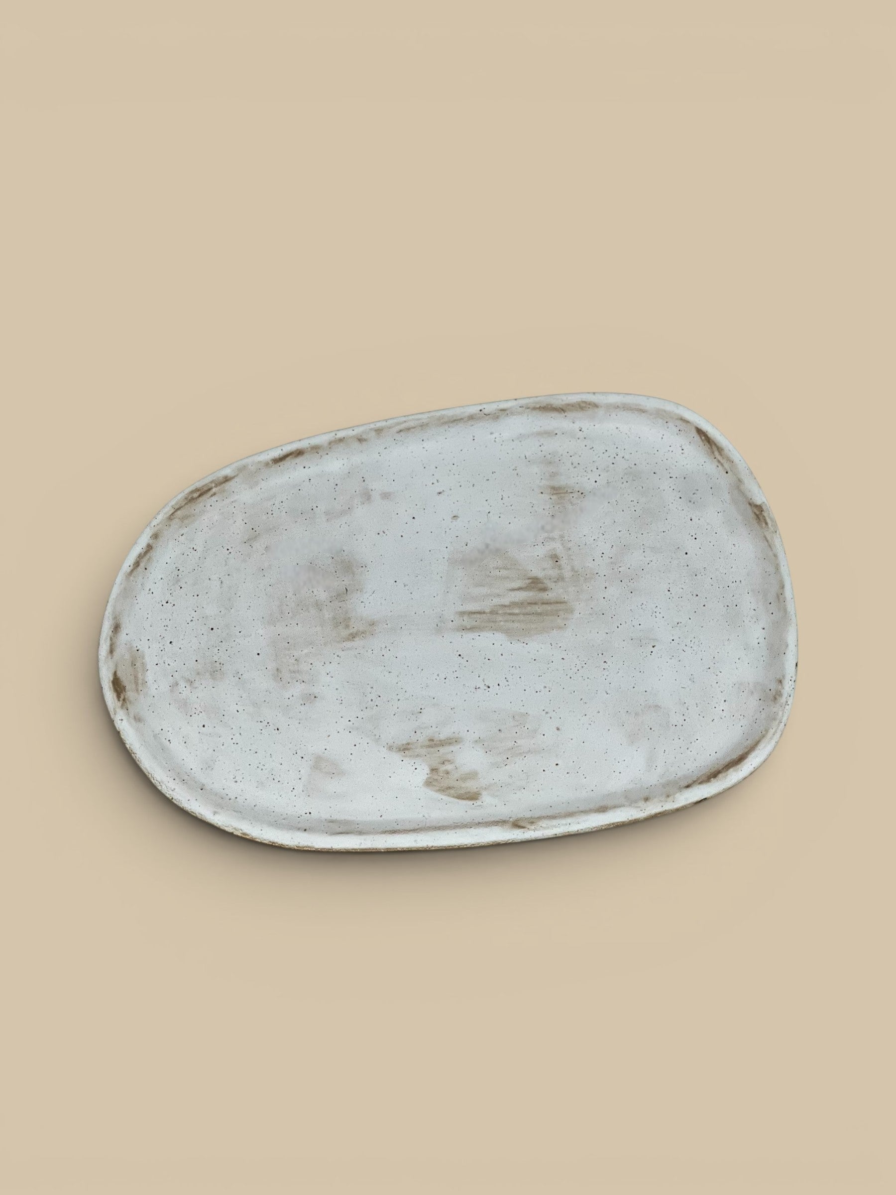 Homestyle Collective Wabi oval serving plate in off-white ceramic with organic form and speckled finish.