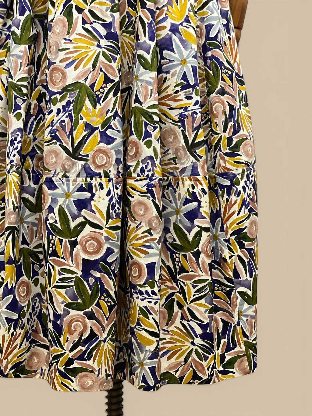 Homestyle Collective watercolor floral A-line midi skirt with a flattering fit and flowing silhouette. Features a vibrant floral print in blue, pink, yellow, and green.