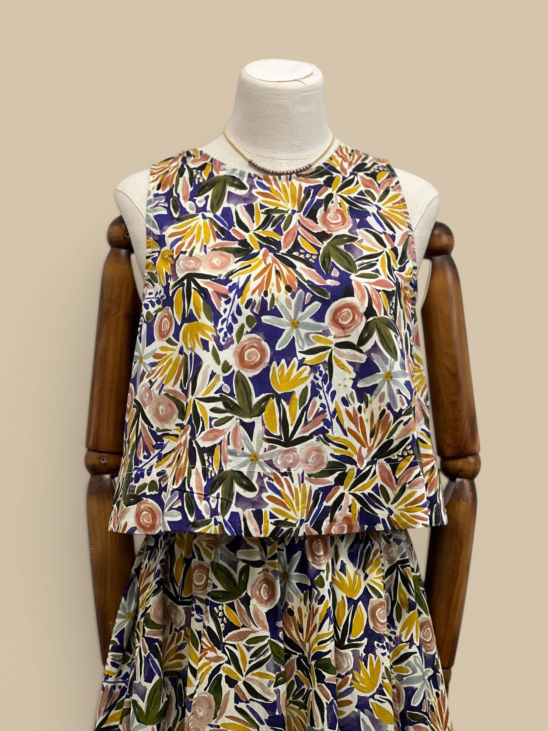Homestyle Collective watercolor floral sleeveless top with round neckline and relaxed fit. Multi-color botanical print.