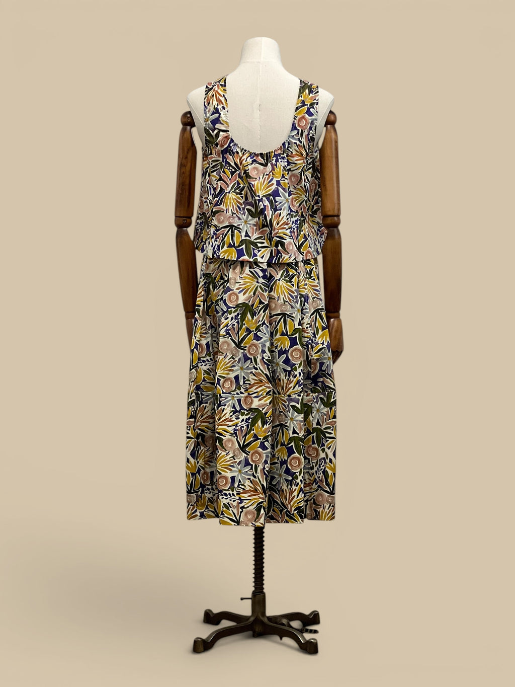 Homestyle Collective watercolor floral sleeveless top with round neckline and tiered hem. Multi-color botanical print.