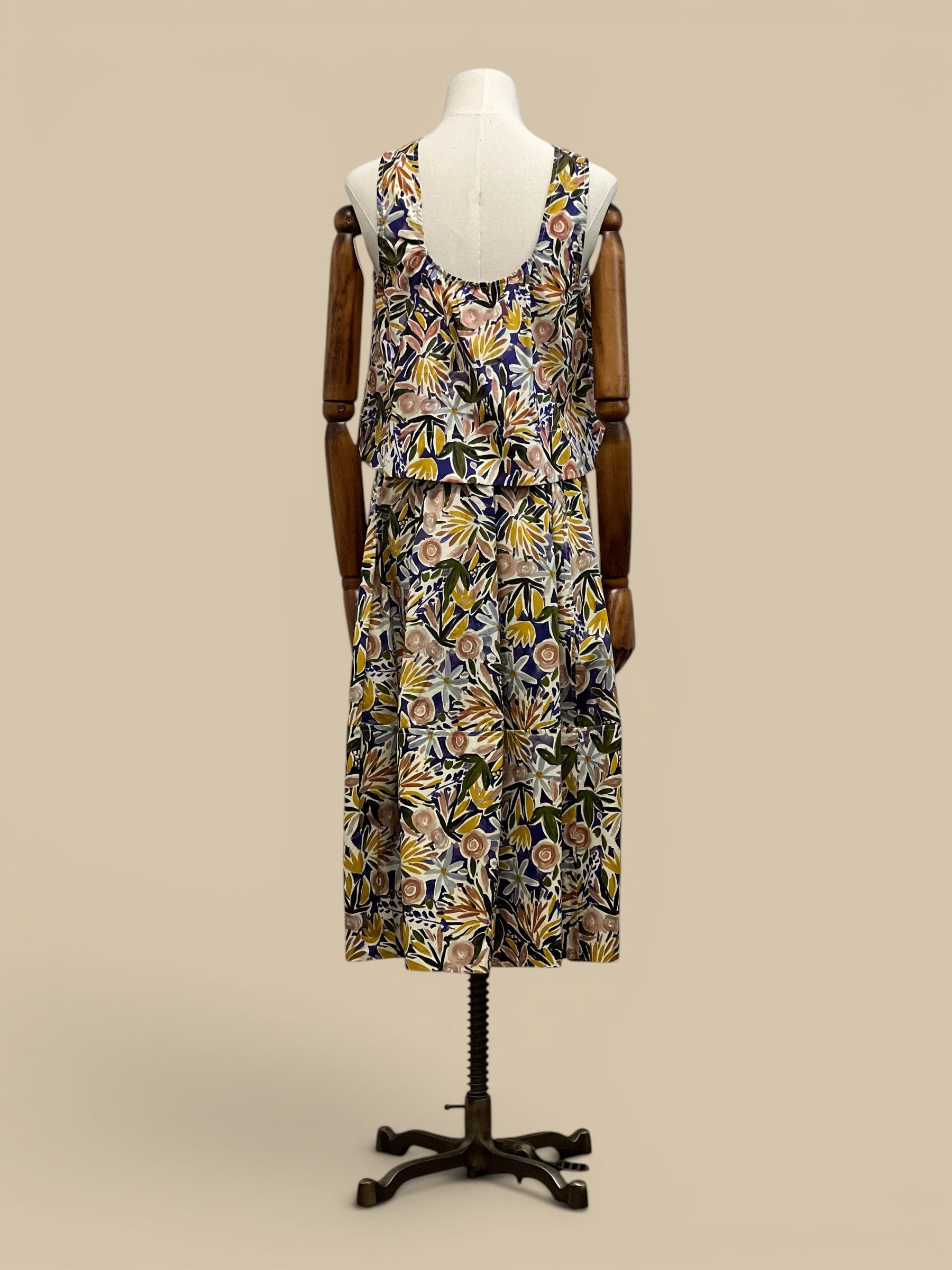 Homestyle Collective watercolor floral sleeveless top with round neckline and tiered hem. Multi-color botanical print.